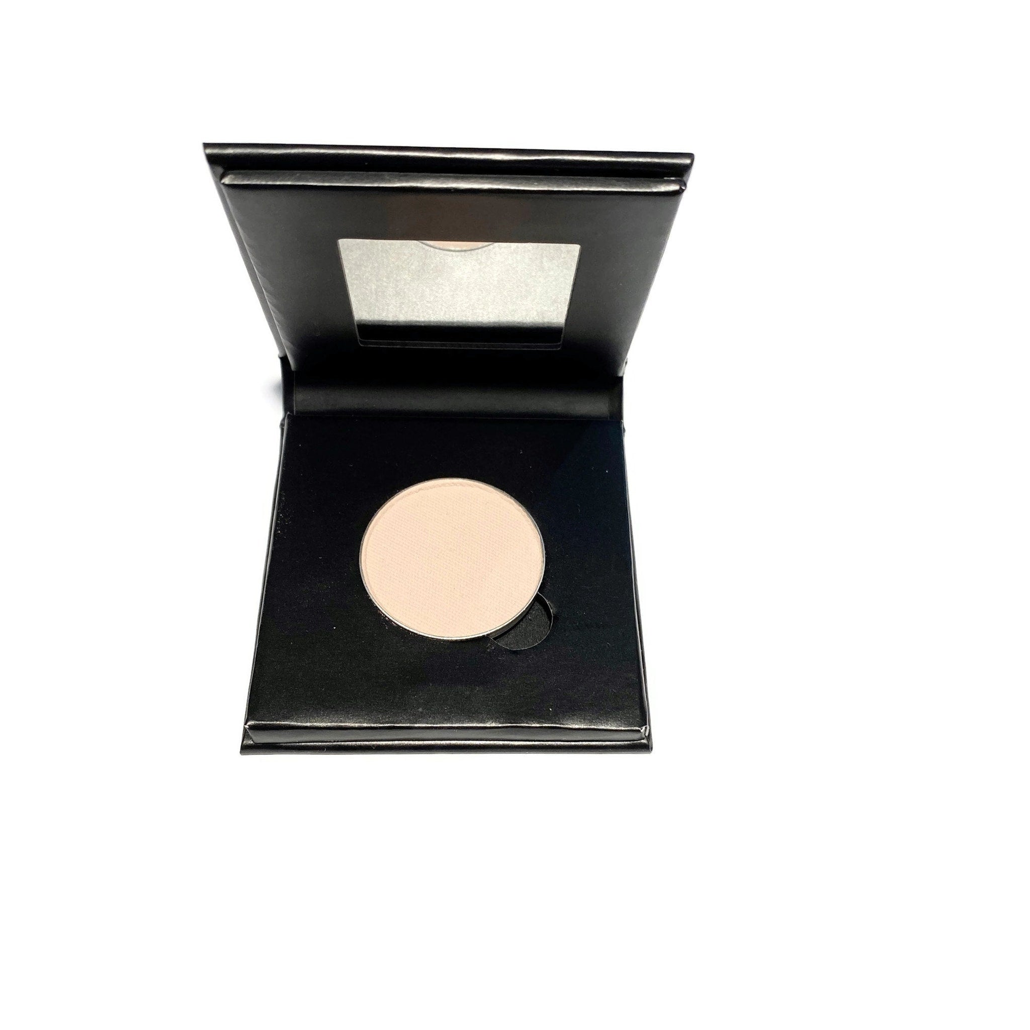 Side view of barely bisque eyeshadow compact showing paperboard case texture and refillable hinge detail