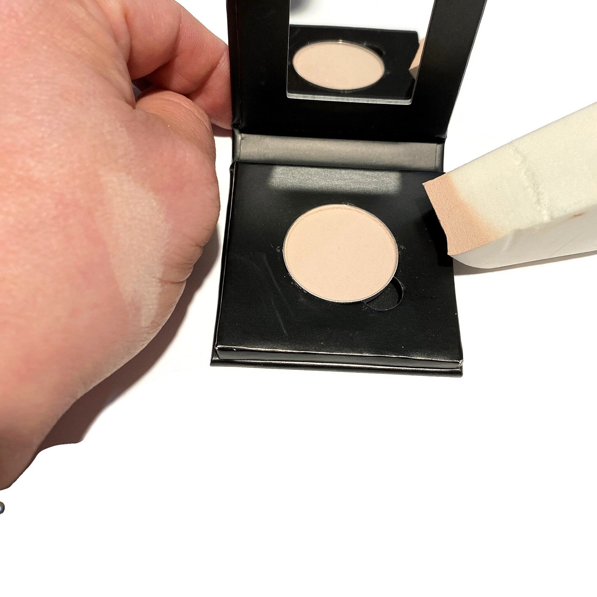 Square paperboard eyeshadow compact in soft bisque with refillable pan and minimalist design