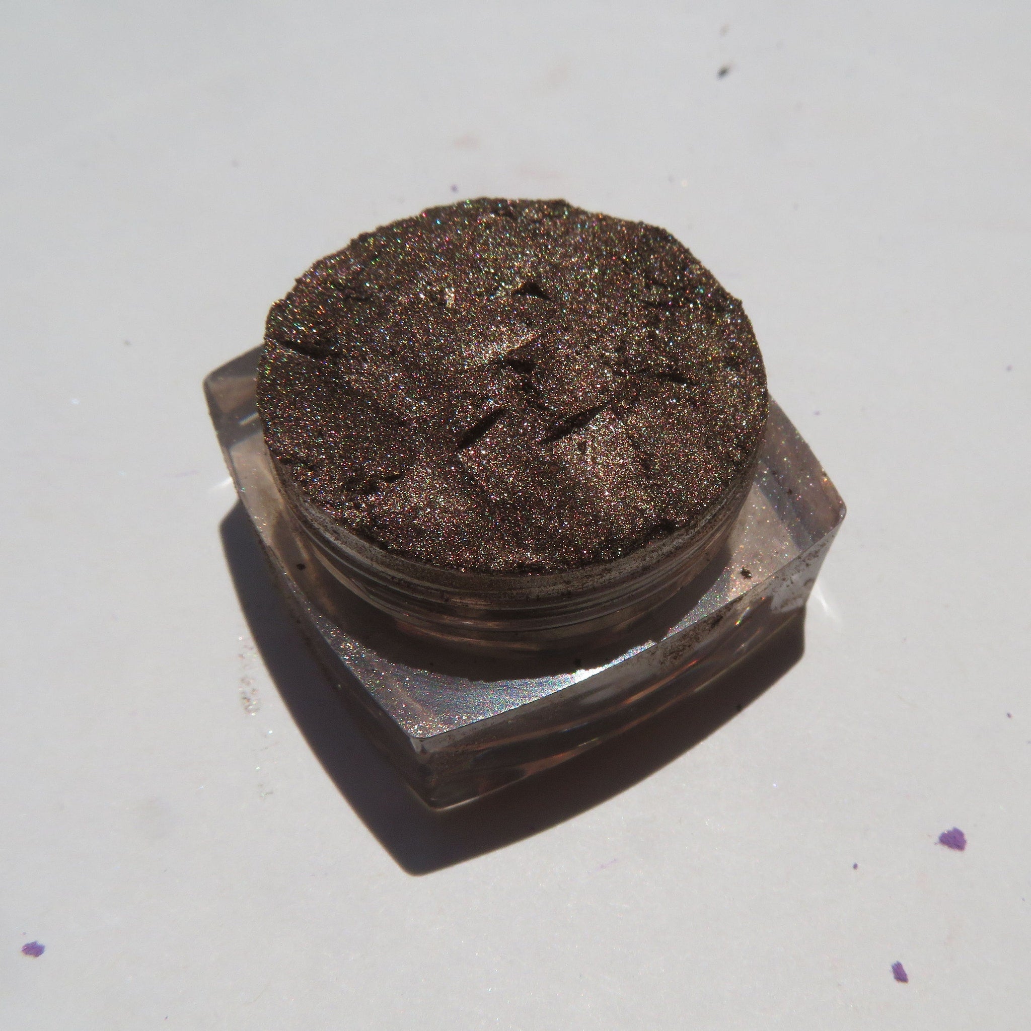 Hand applying chocolate brown gold shimmer loose eyeshadow with a brush for a soft, blended look