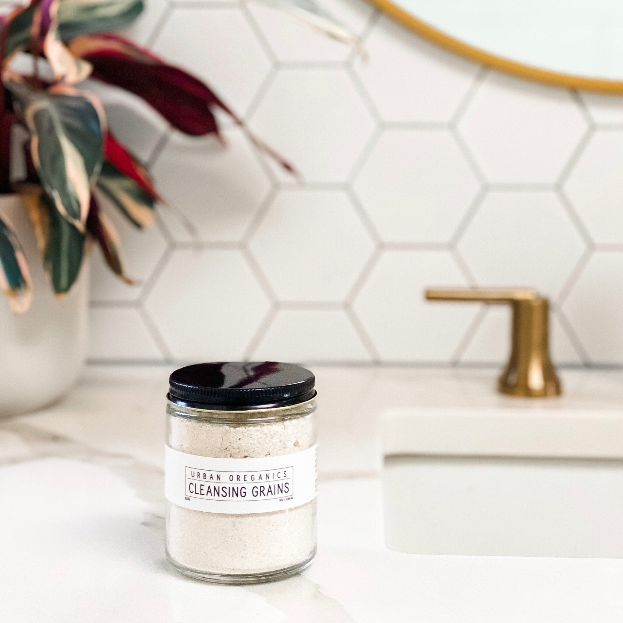 Cleansing grains in a glass jar with a black lid, white label, and light-colored grains