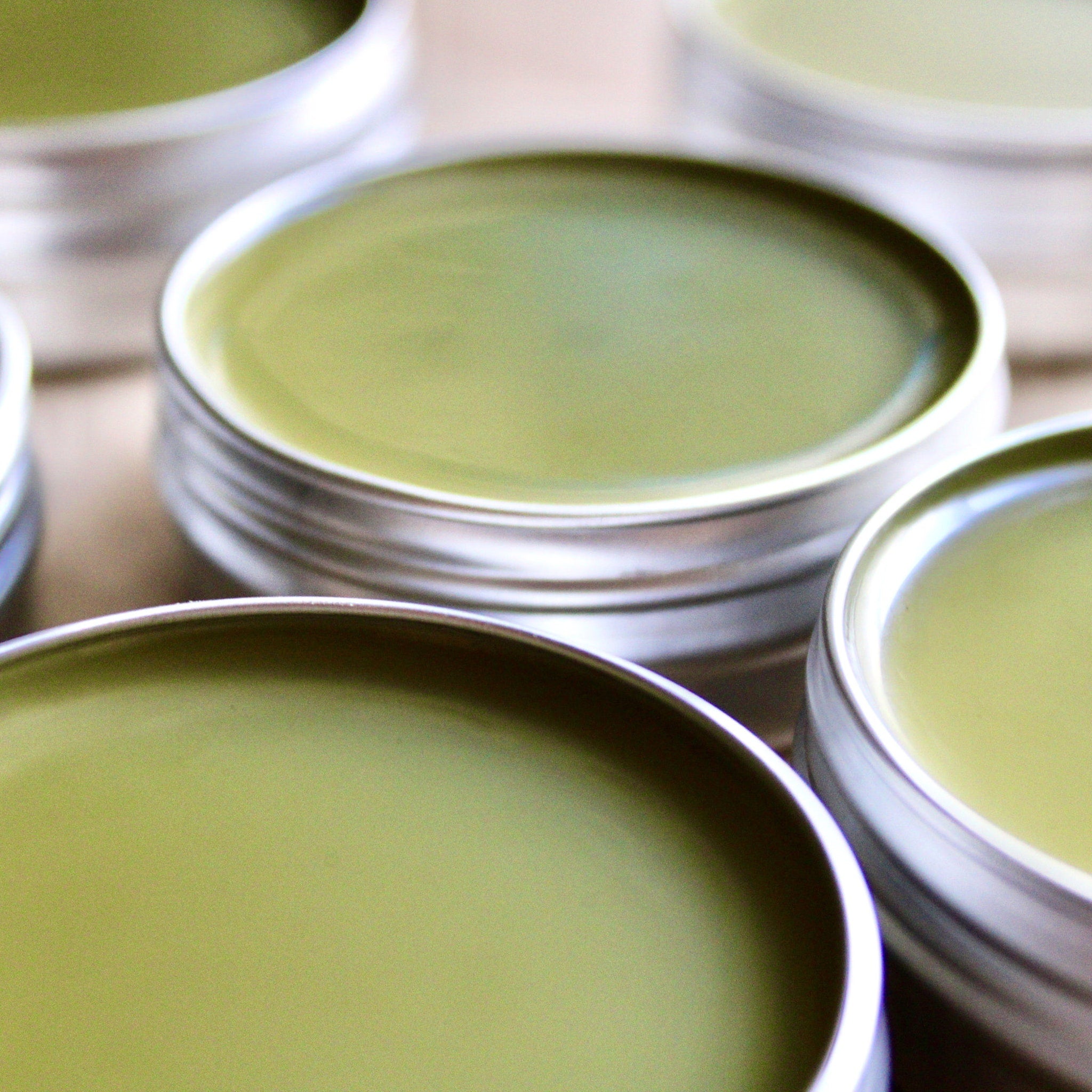 Green balm in silver tins, close-up view of multiple containers, product display