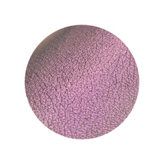 Side angle view of vegan multichrome eyeshadow pan shifting from orange to violet with olive undertones