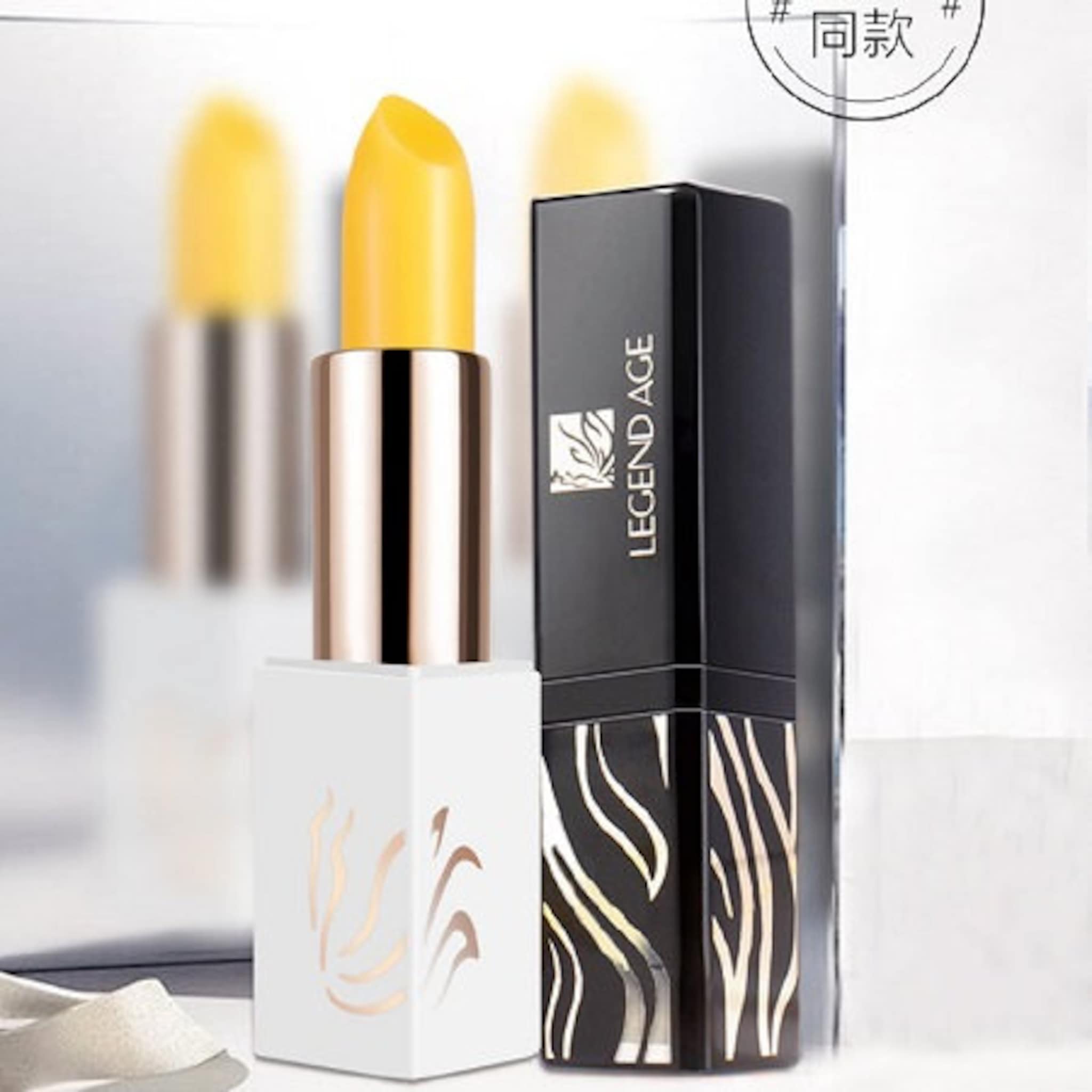 Lipstick with yellow balm, white and black patterned tubes, Legend Age brand name visible