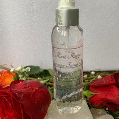 Rosewater facial toner in clear glass bottle with label, surrounded by red roses and flowers