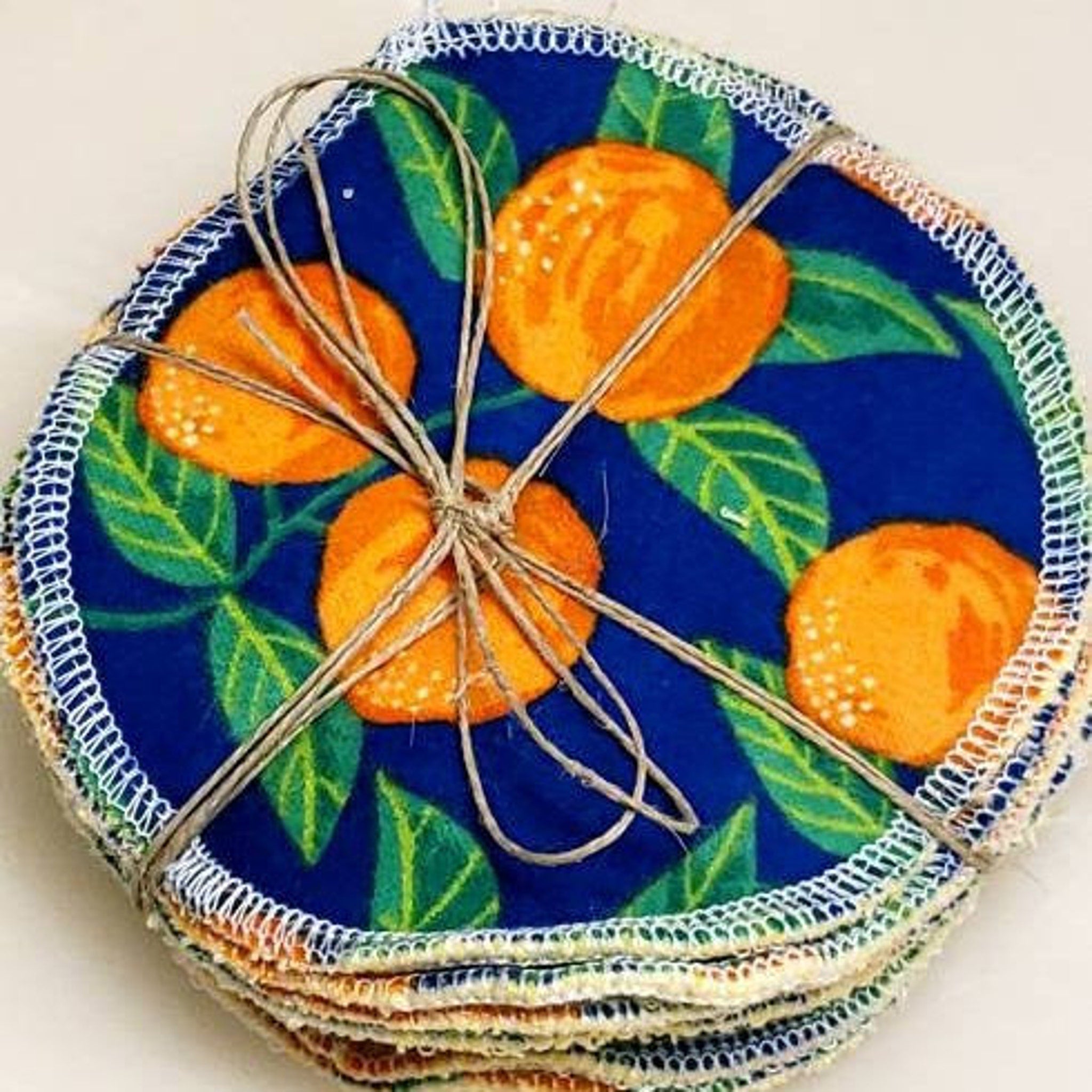 Facial rounds blue orange floral pattern, white stitched edge, tied with twine