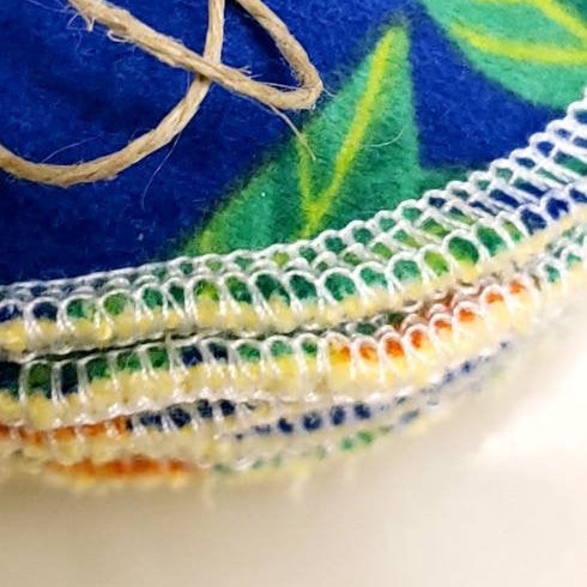 Round fabric pads with blue, green, and yellow floral pattern, white stitched edges, and twine detail