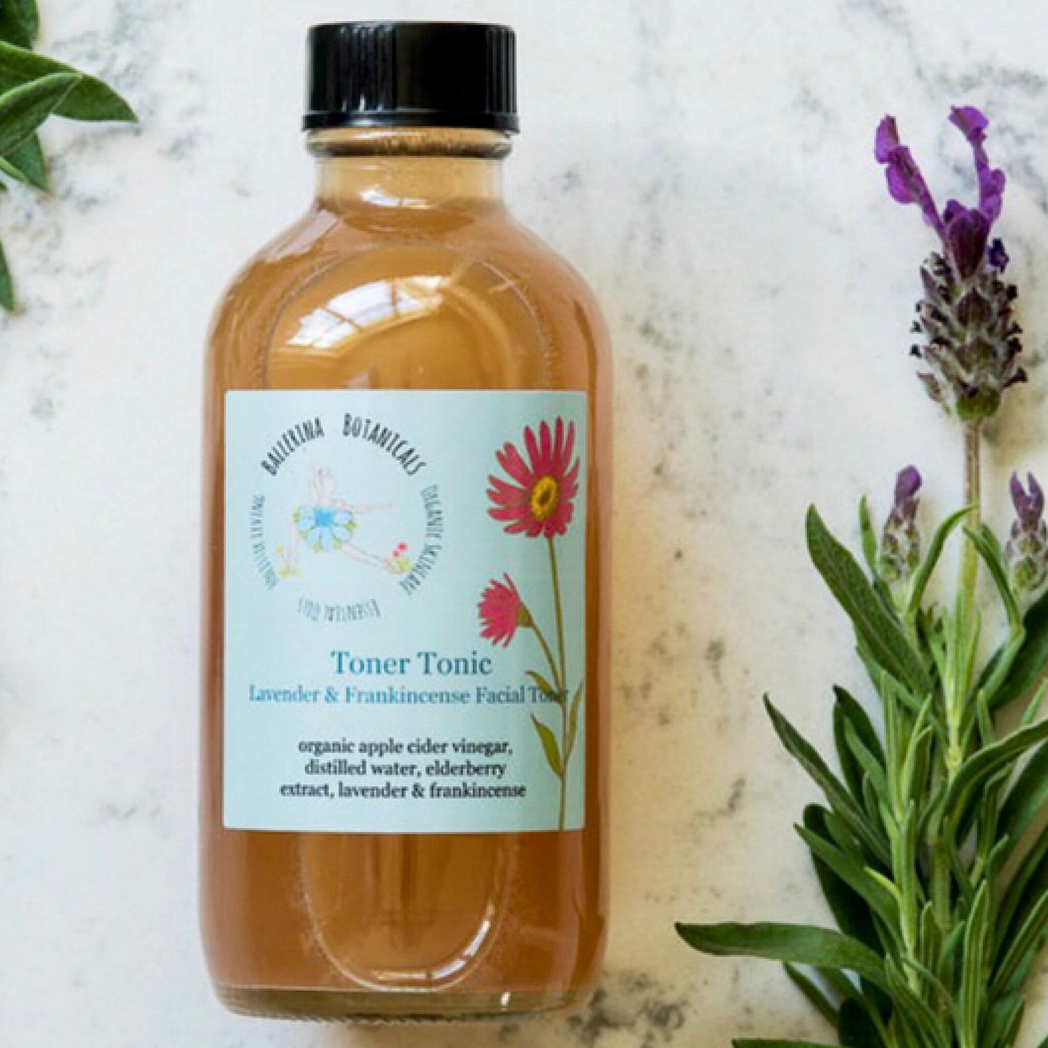 Toner Tonic bottle with brown liquid, black cap, and blue label with floral design and text