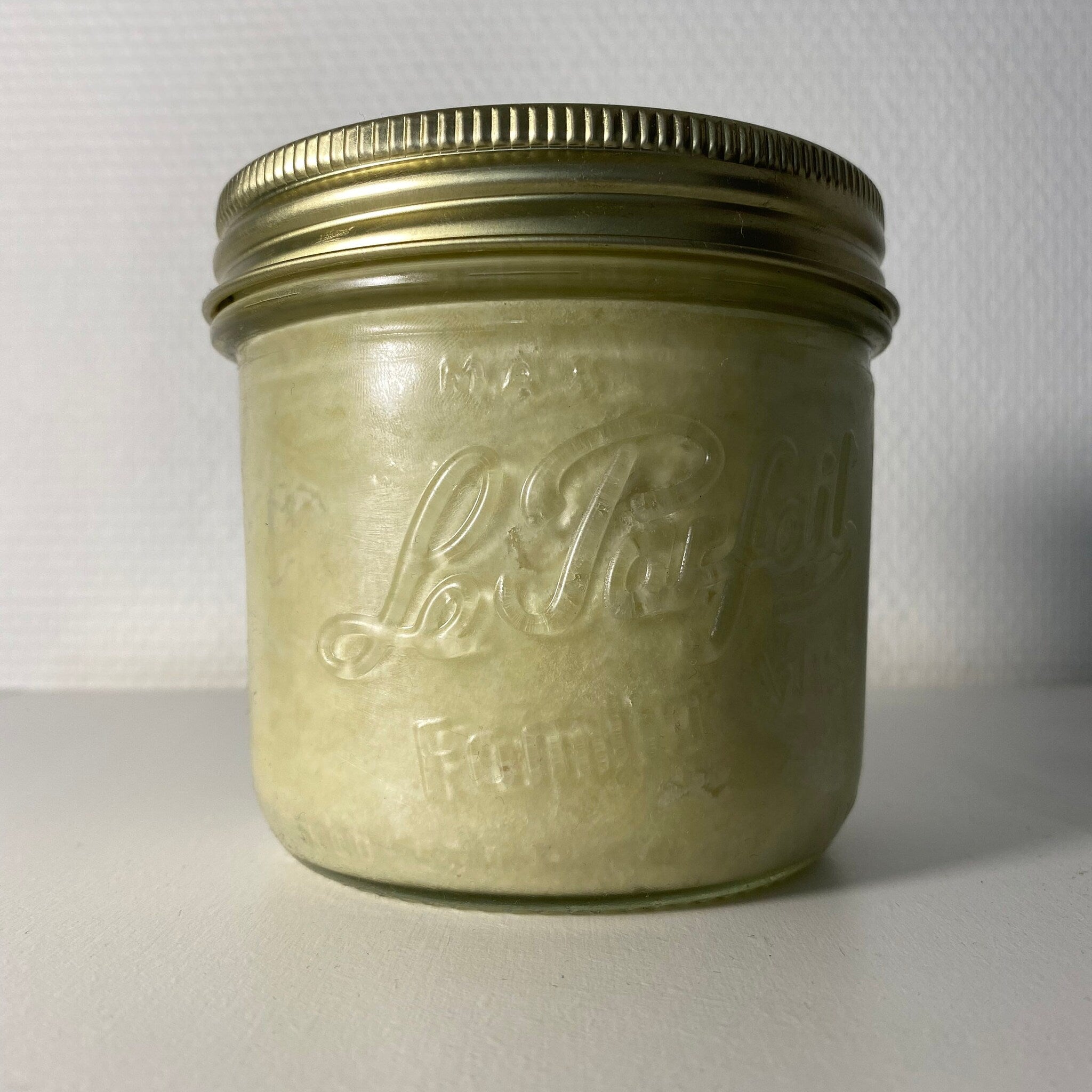 Glass jar with gold lid, "Le Parfait" embossed, filled with light green substance