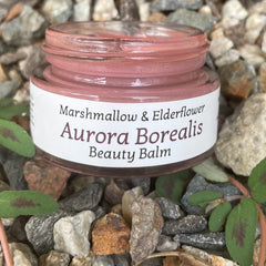 Close-up of Aurora Borealis Beauty Balm Eye Shadow in iridescent shades with sleek black compact packaging