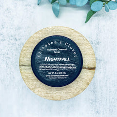 Activated charcoal scrub in black jar on wood, Chineshasclosetllc brand visible