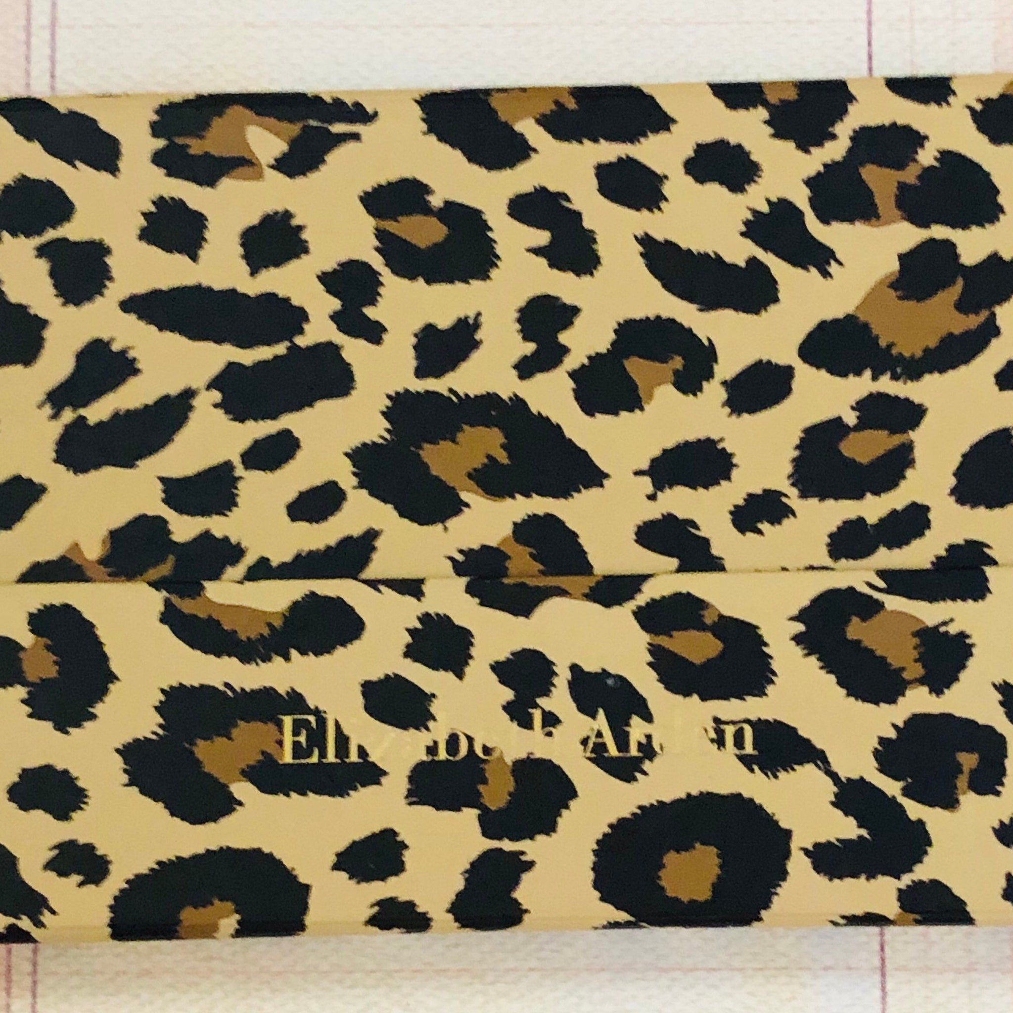 Elizabeth Arden leopard-print eyeshadow palette open to reveal 12 ombré shades with mirror inside