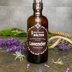 Lavender hydrosol bottle, brown glass, white label, with Alma Baltica text, and purple lavender flowers
