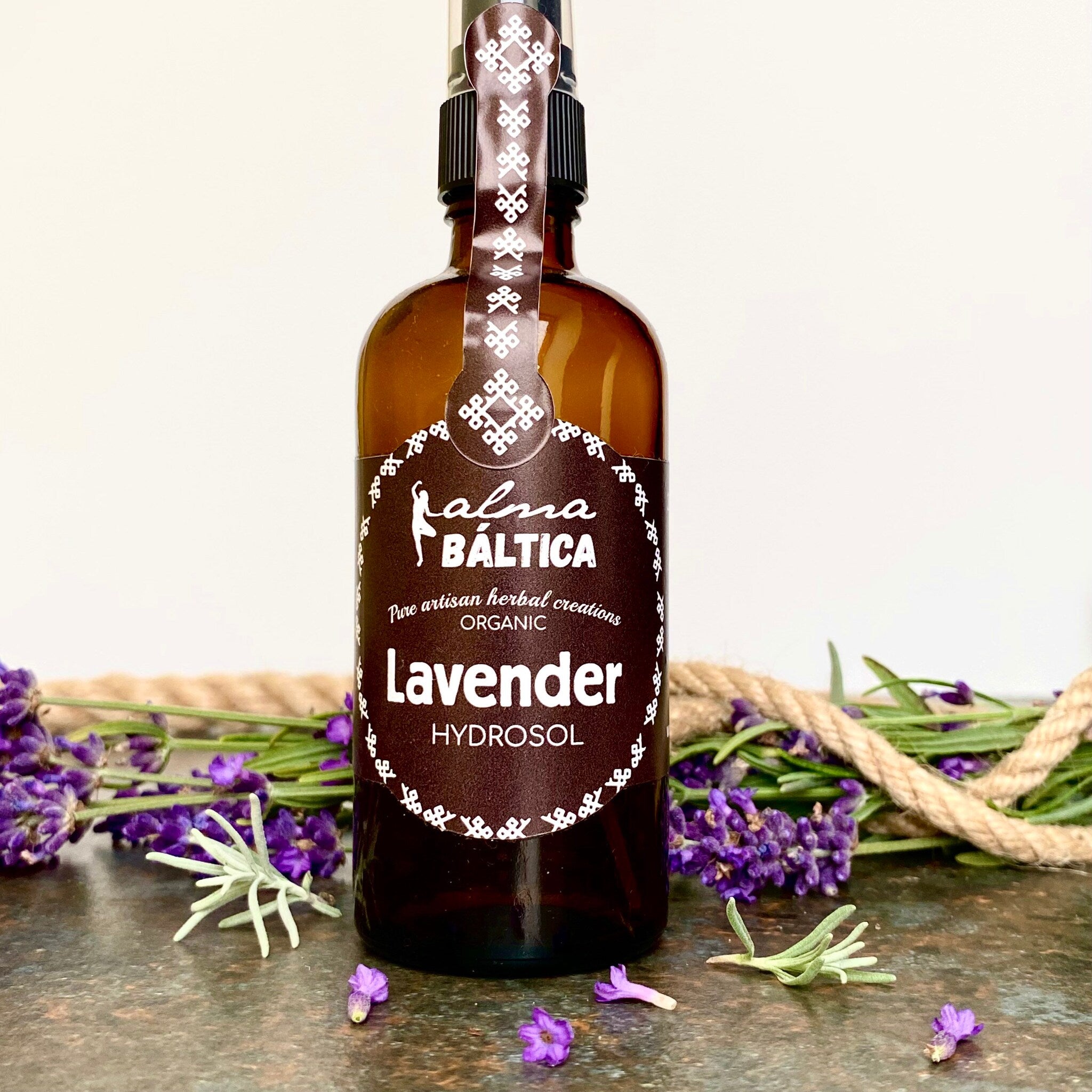 Lavender Hydrosol bottle, brown glass, white label with Alma Baltica text, purple flowers around