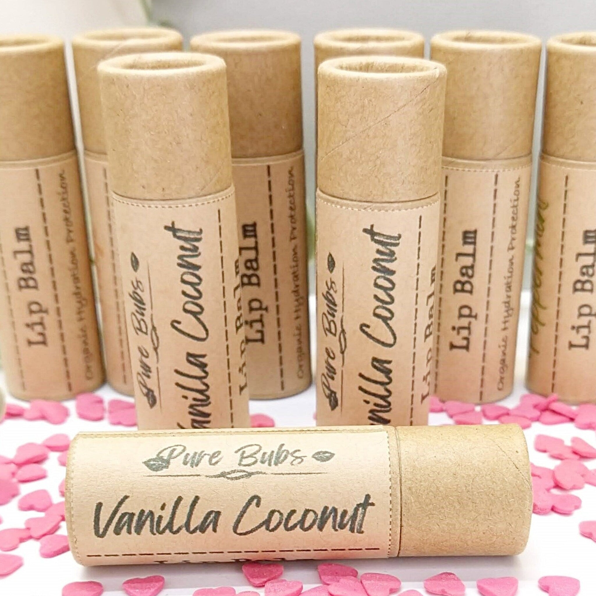 Lip balm tubes in natural cardboard with Vanilla Coconut text and pink hearts around them