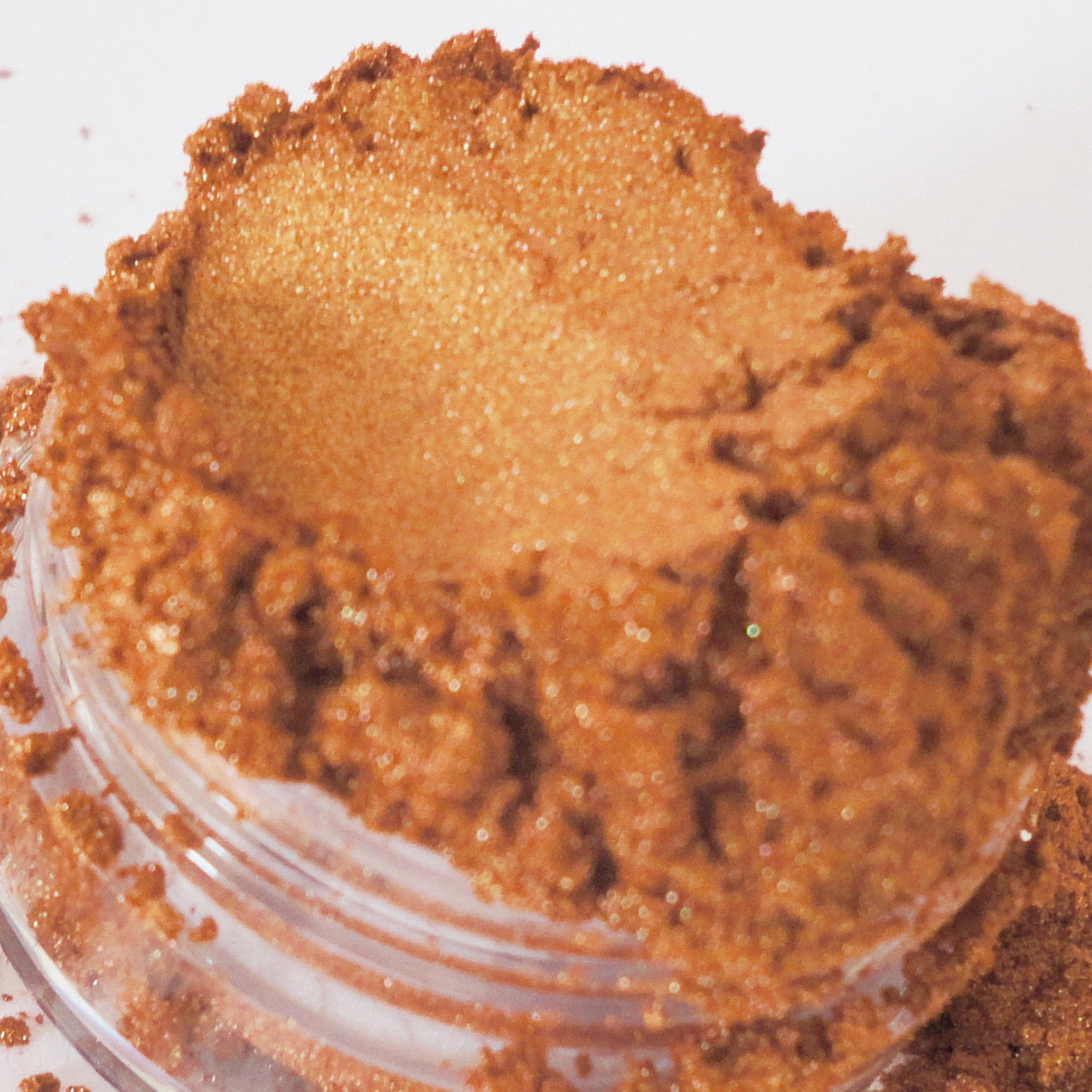 Close-up of pewter shimmer eyeshadow pan showing metallic brown gold pigment texture