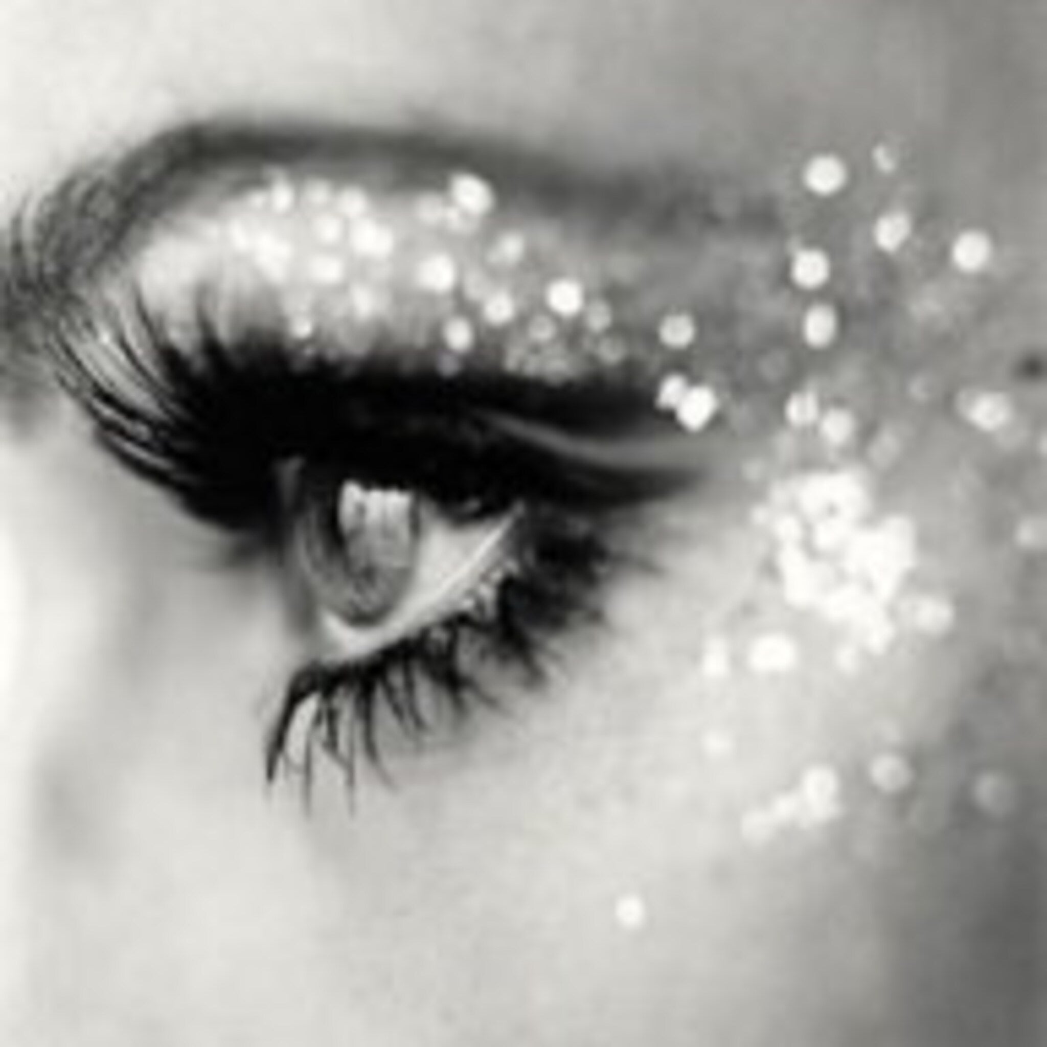 White iridescent jar of Star Dust glitter eyeshadow with gold lid on marble surface