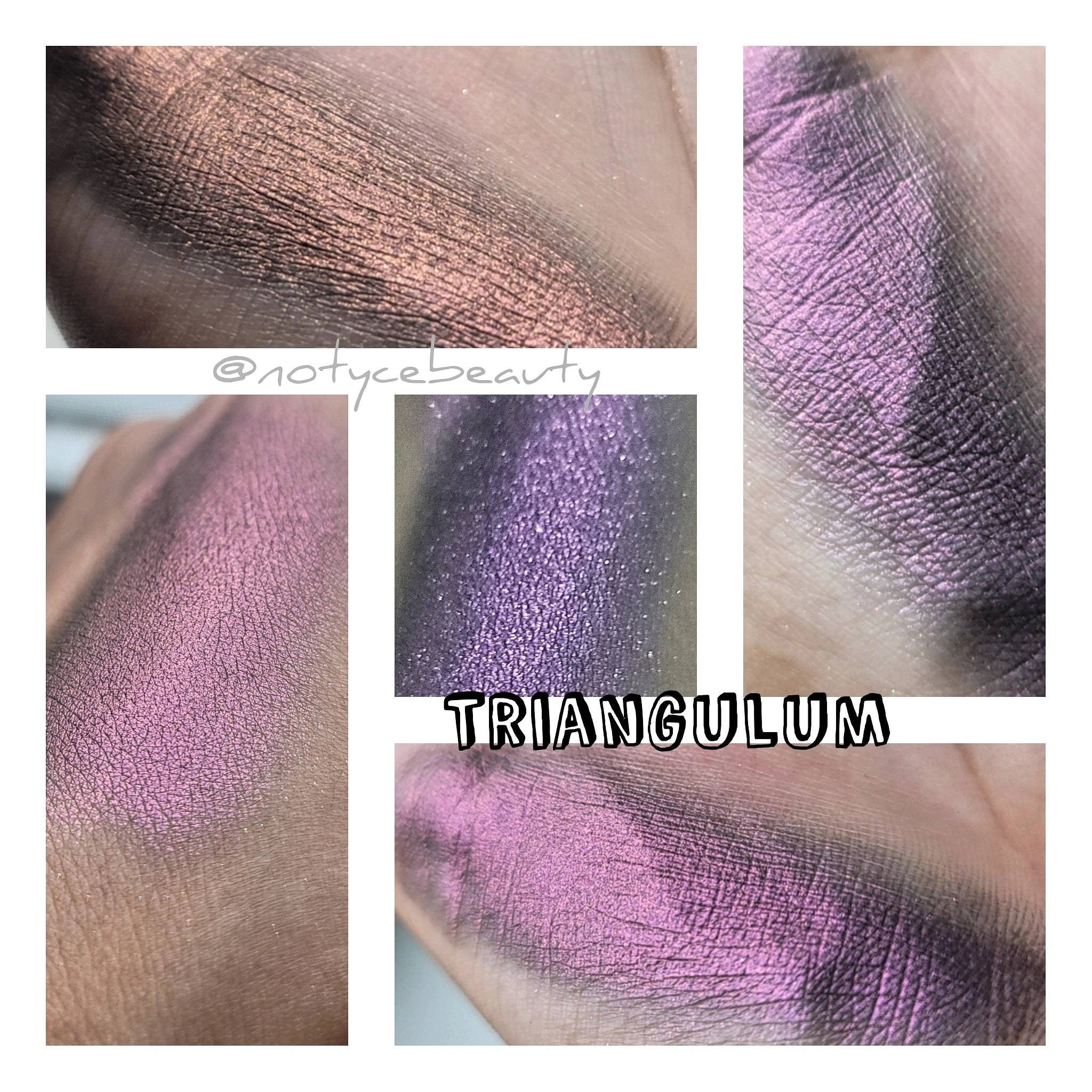 Vegan multichrome eyeshadow pan in orange, red, pink, and violet with olive shift, displayed on white background