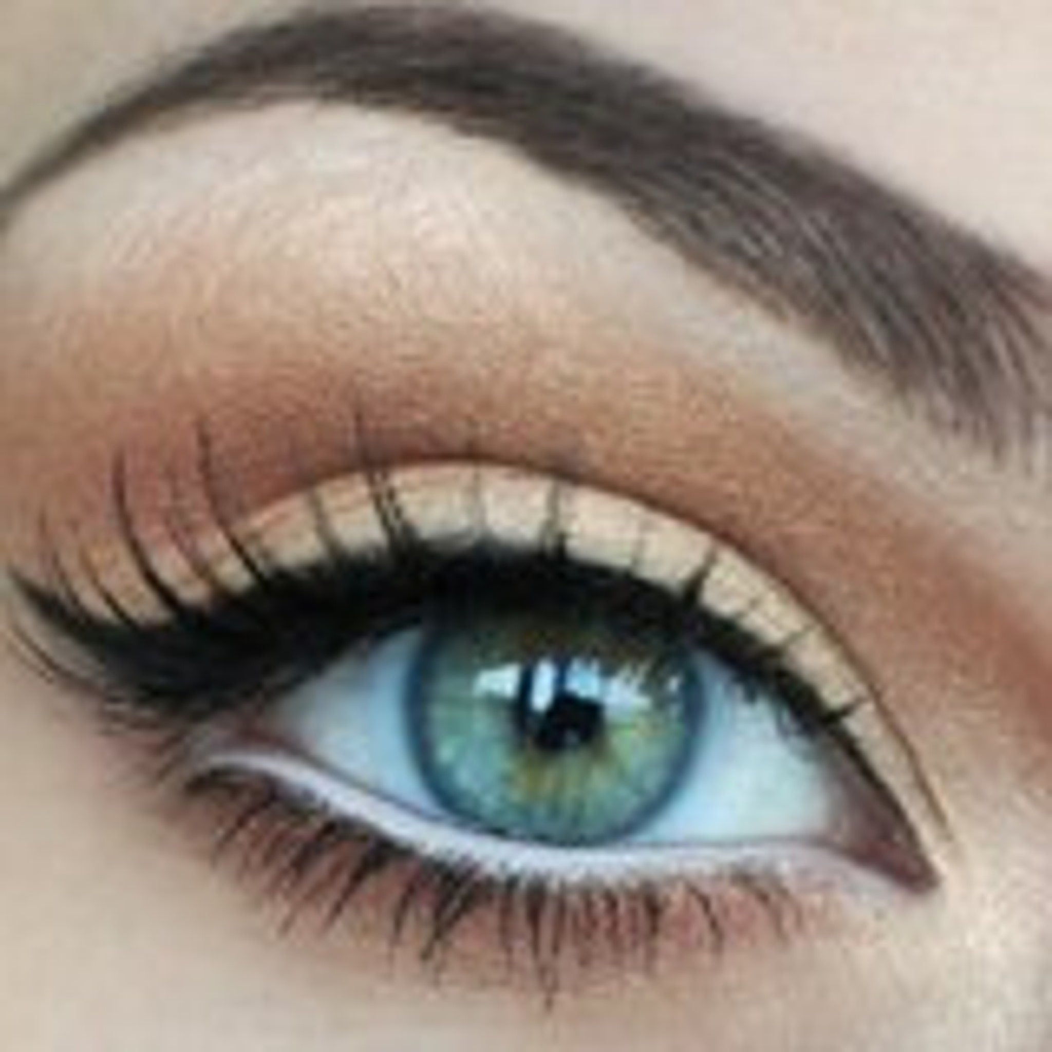Eye makeup with blue-green eye, brown eyeshadow, and black eyeliner applied to the upper lid