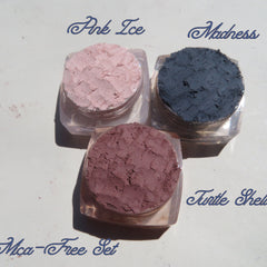 Three matte loose mineral eyeshadows in glass jars with black lids, showcasing vegan mica pigments in neutral earthy tones.