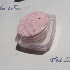 Close-up of three matte loose mineral eyeshadows in earthy tones with fine mica texture, cruelty-free vegan makeup