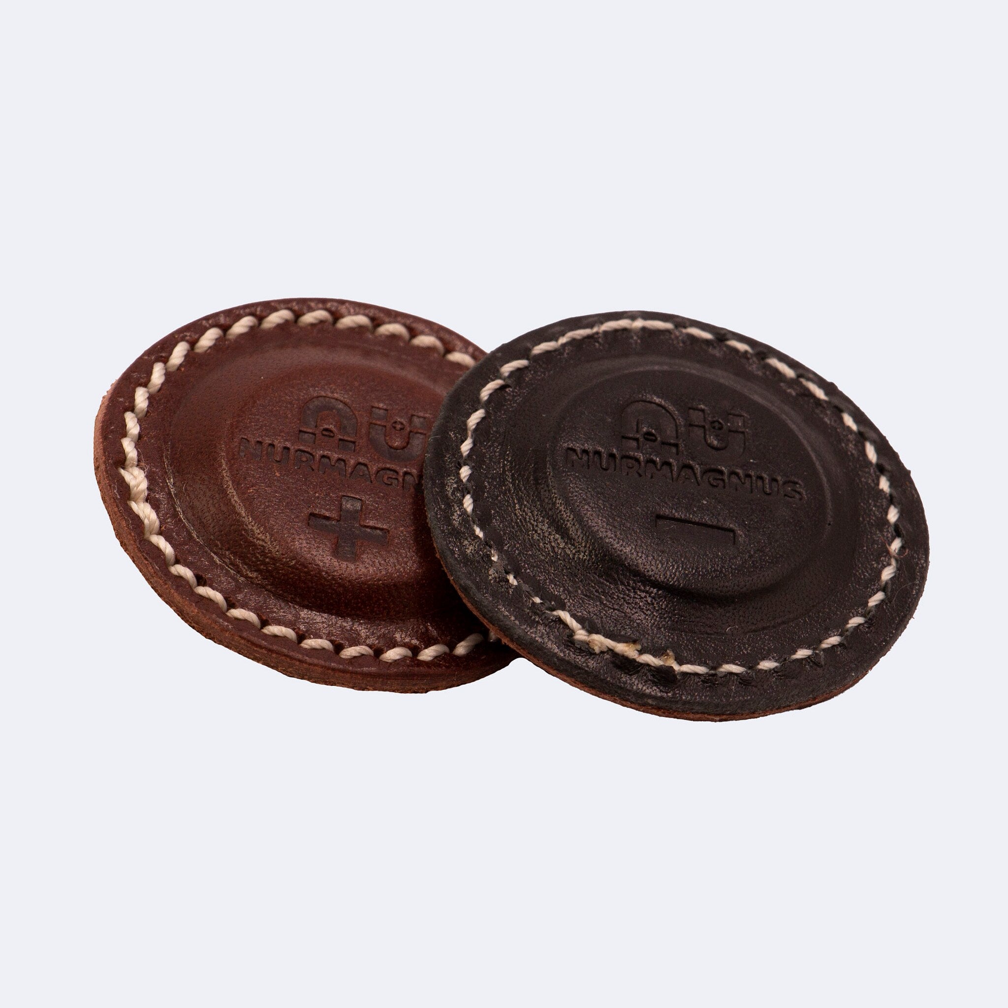 Leather discs, brown and black, stitched edge, Nurmagnus logo visible