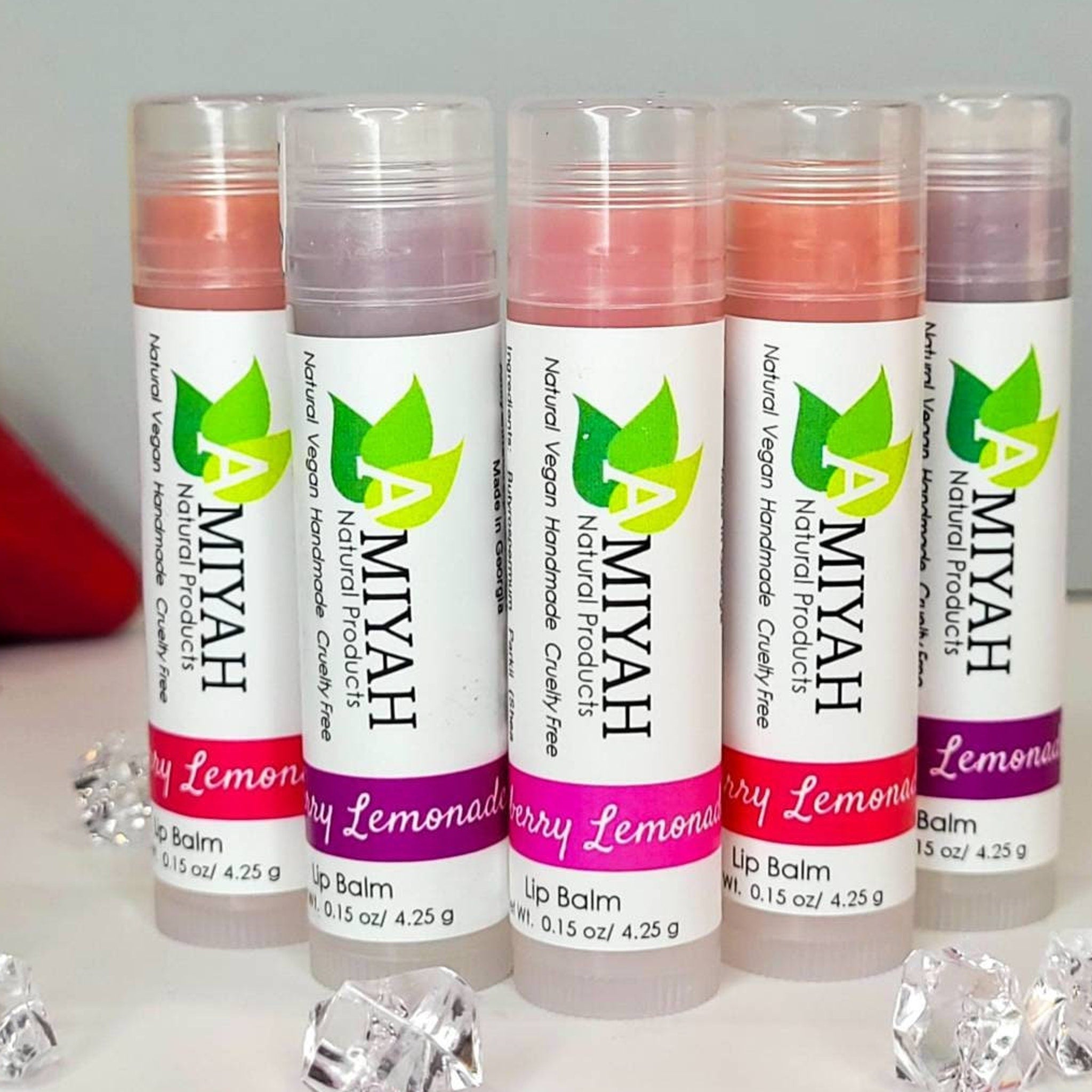 Lip balm tubes with white, pink, and clear packaging, Amiyah Natural Products brand visible