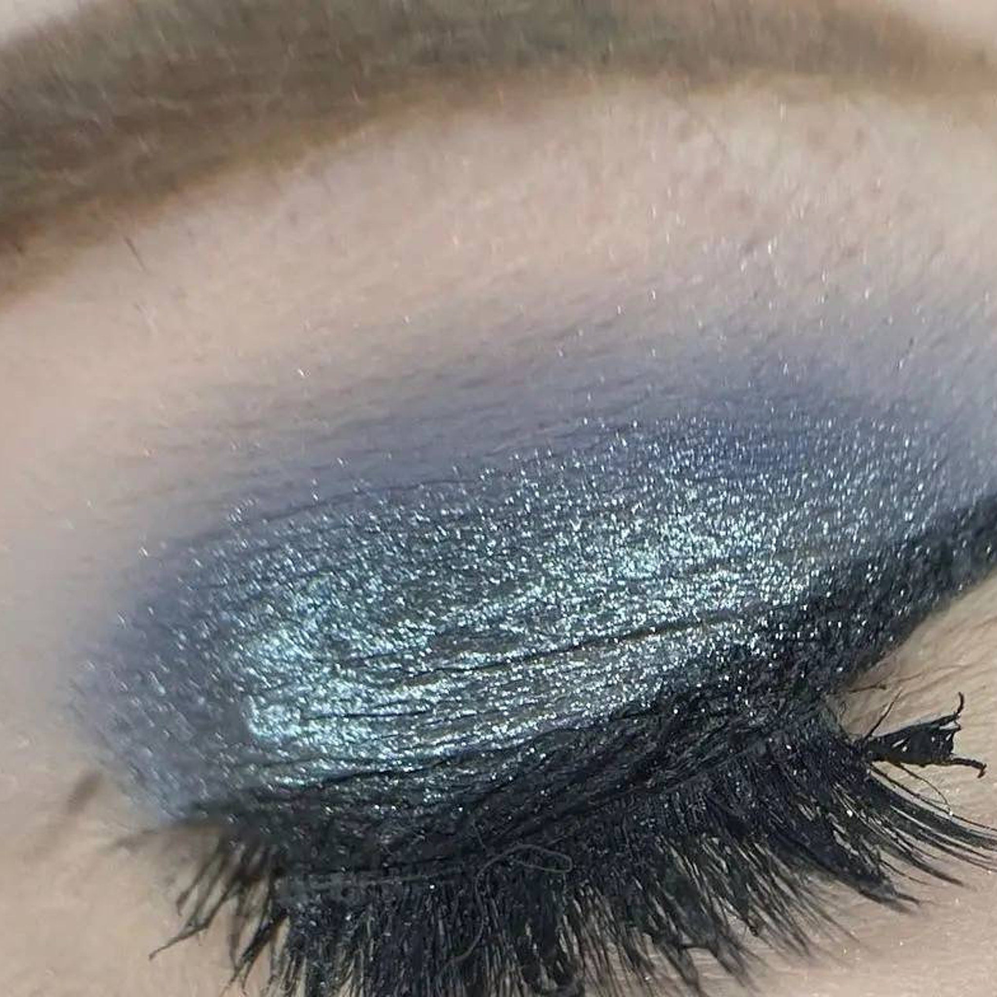Side angle view of Moonrise Chameleon Eye Shadow showing icy blue to grey shift with sparkling shimmer particles