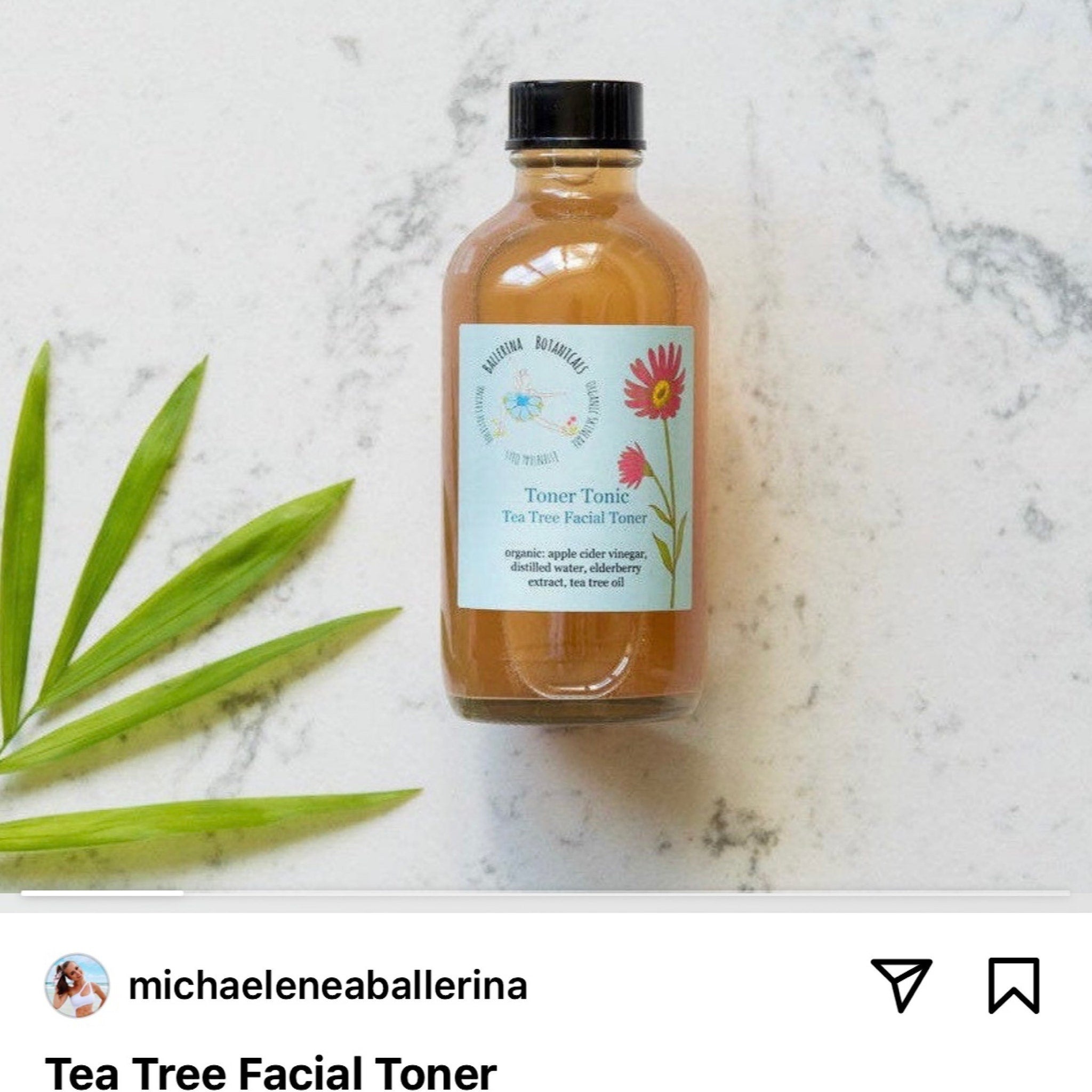 Tea Tree Facial Toner in a brown glass bottle with black cap and floral label on white surface