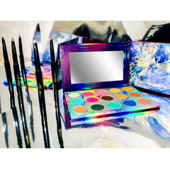 Close-up of fingertips applying shimmery navy blue and silver eye shadow from palette to eyelid