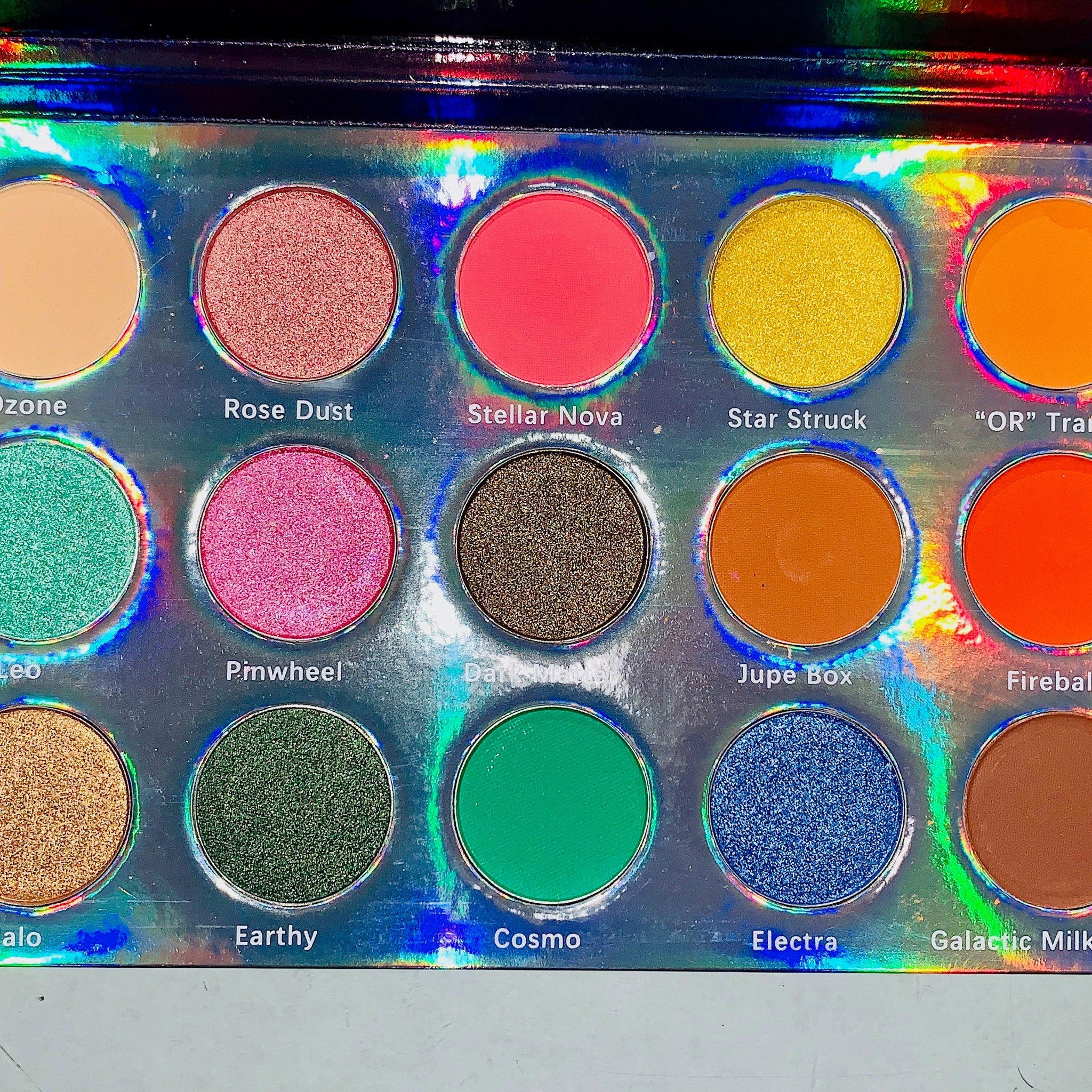 Close-up of Galactic Astronomy palette showing shimmering navy and silver eyeshadows with star-pressed designs