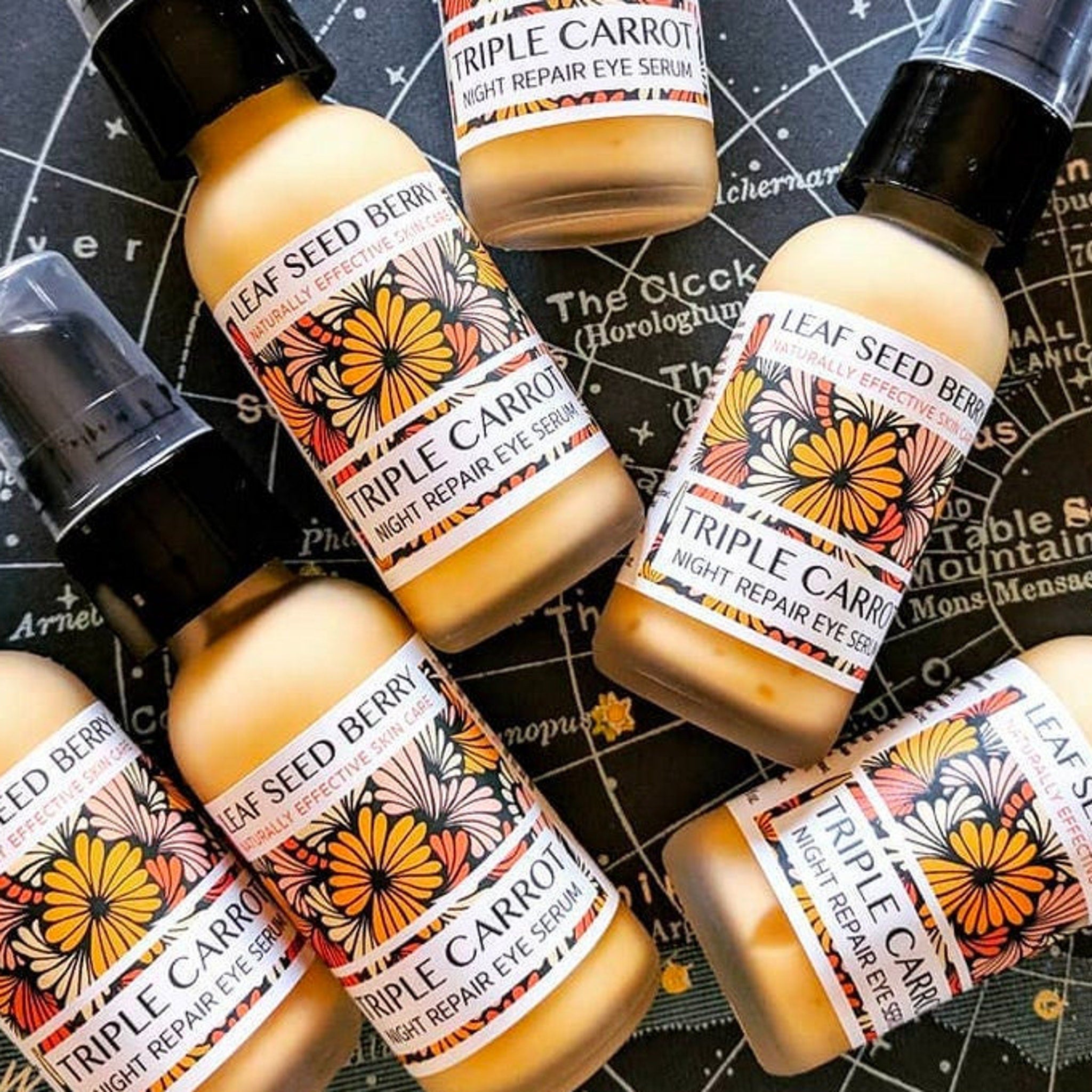 Eye serum bottles with black pump tops, floral labels, and tan liquid contents