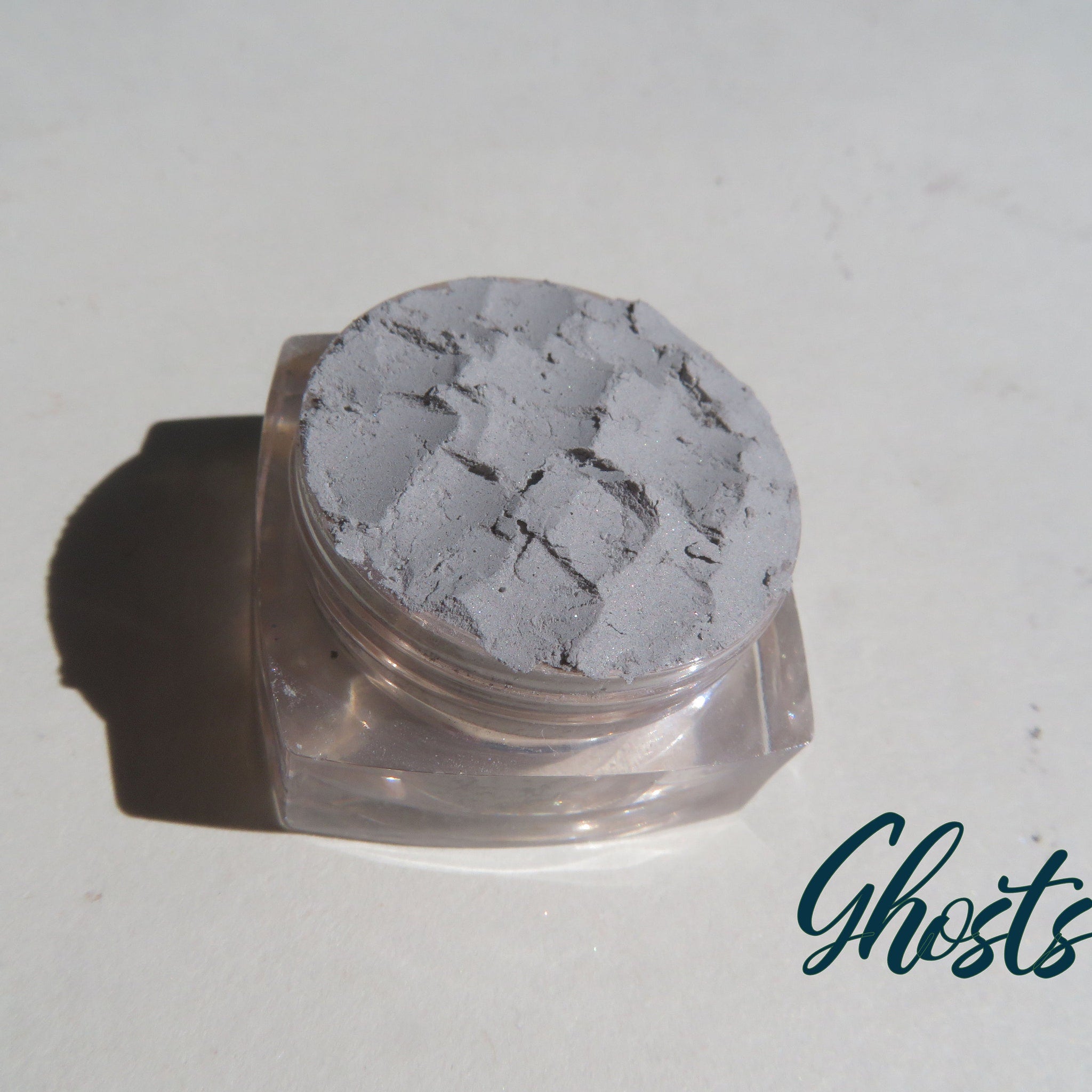 Close-up of pale matte gray mineral eyeshadow in eco-friendly loose powder form with vegan label
