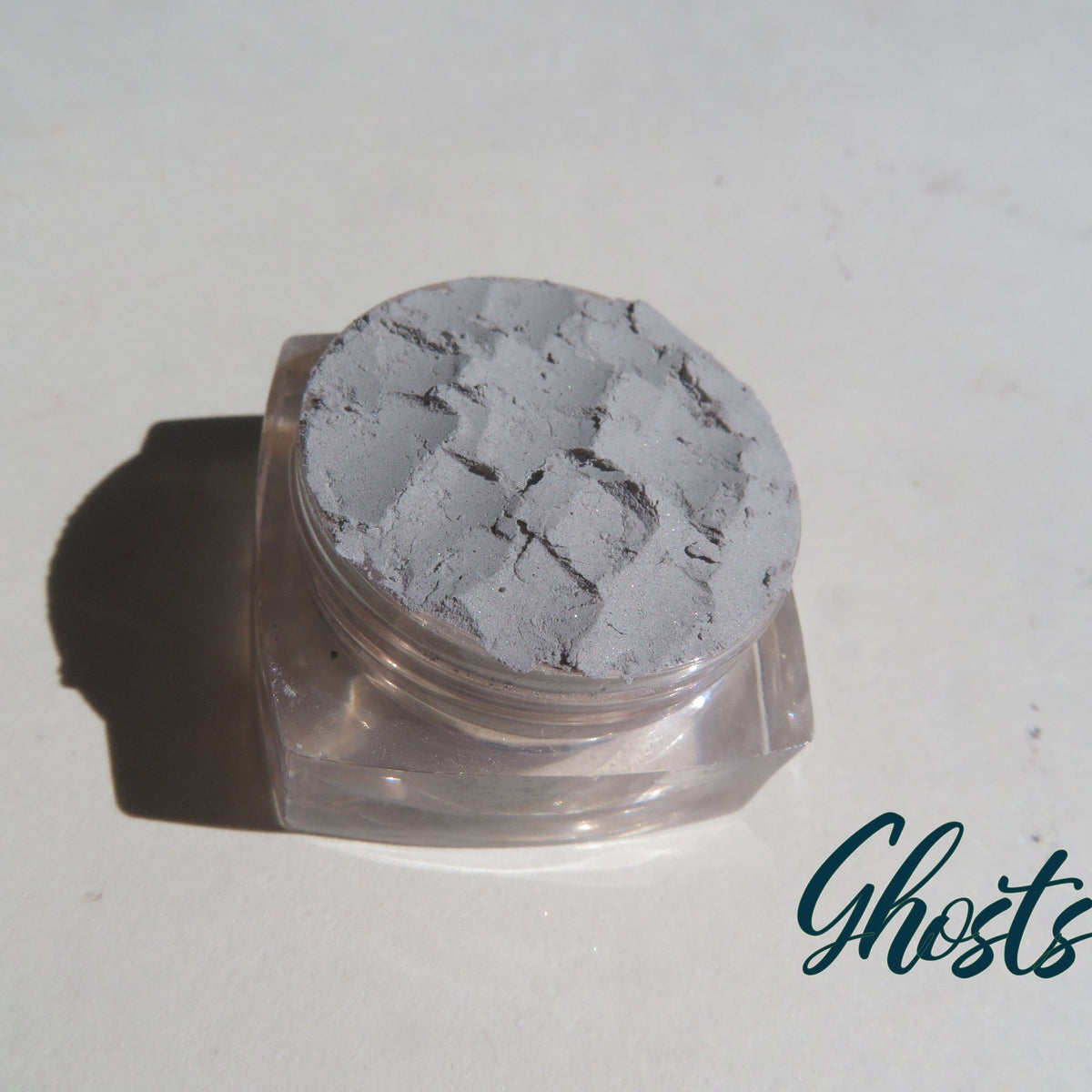 Close-up of pale matte gray mineral eyeshadow in eco-friendly loose powder form with vegan label