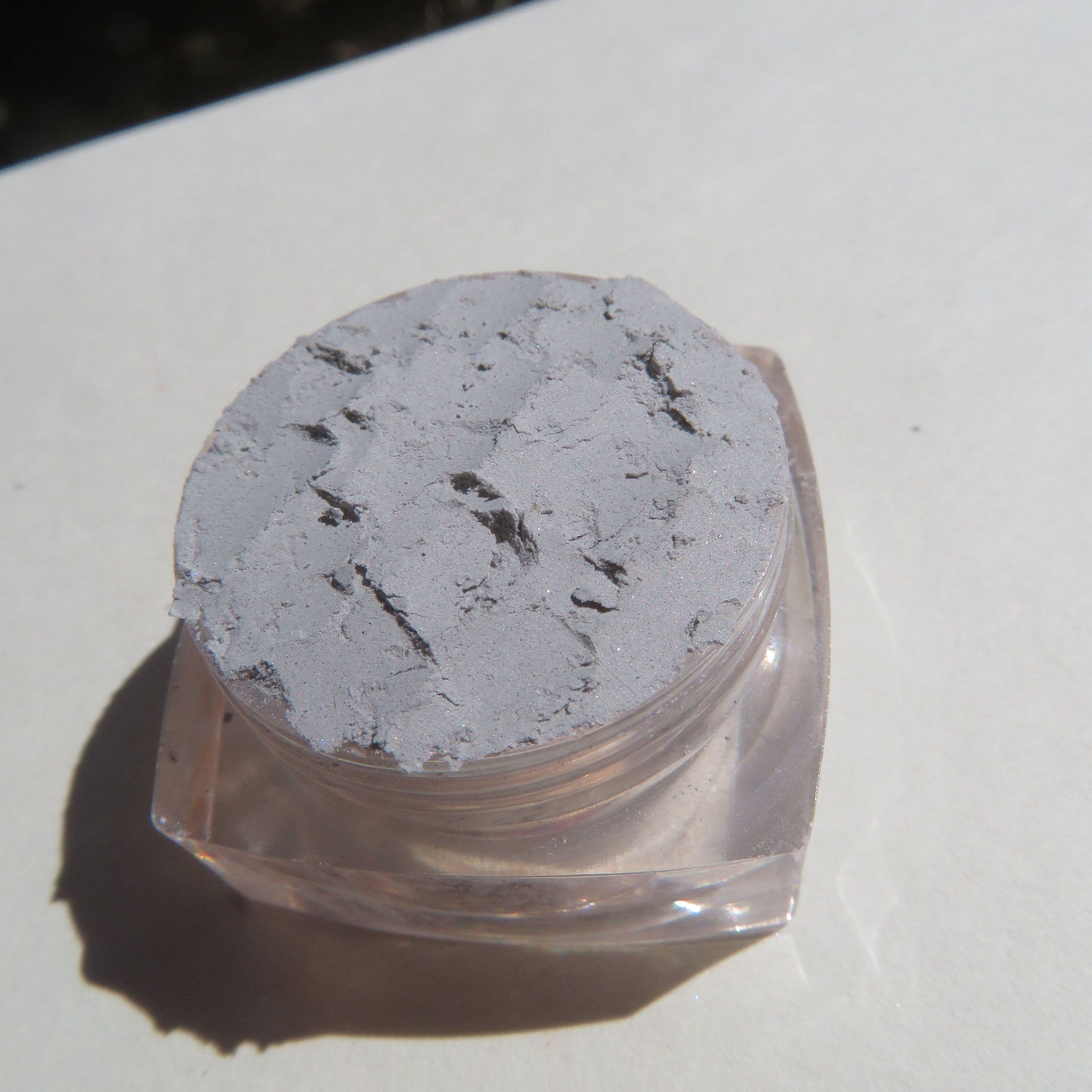 Open compact showing pale matte gray mineral eyeshadow with vegan loose pigment and eco-friendly packaging