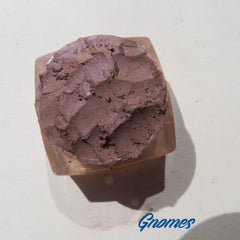 Side view of four matte brown loose mineral eyeshadows in round jars with black lids, showcasing texture and vegan labeling