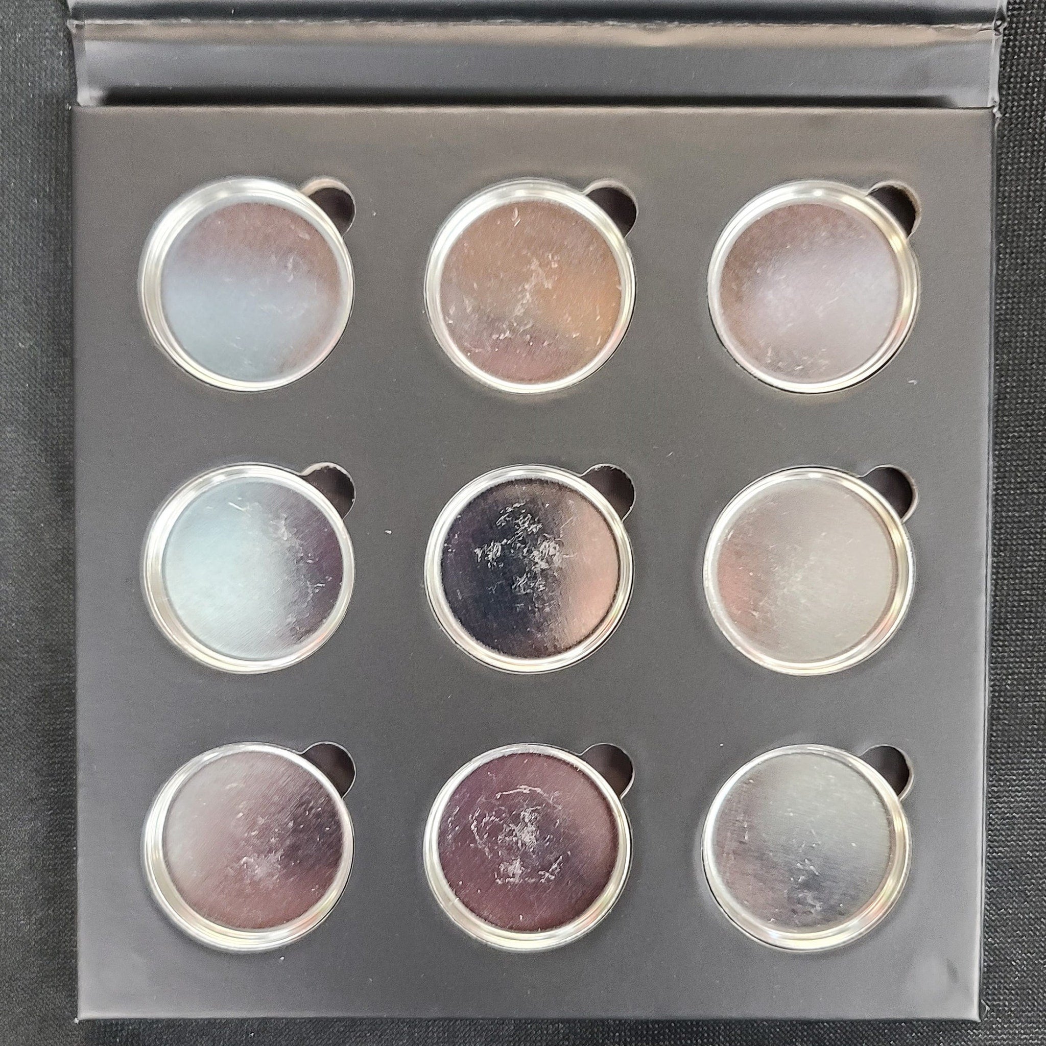 Side view of matte black magnetic eyeshadow palette showing nine square pans in neutral shades