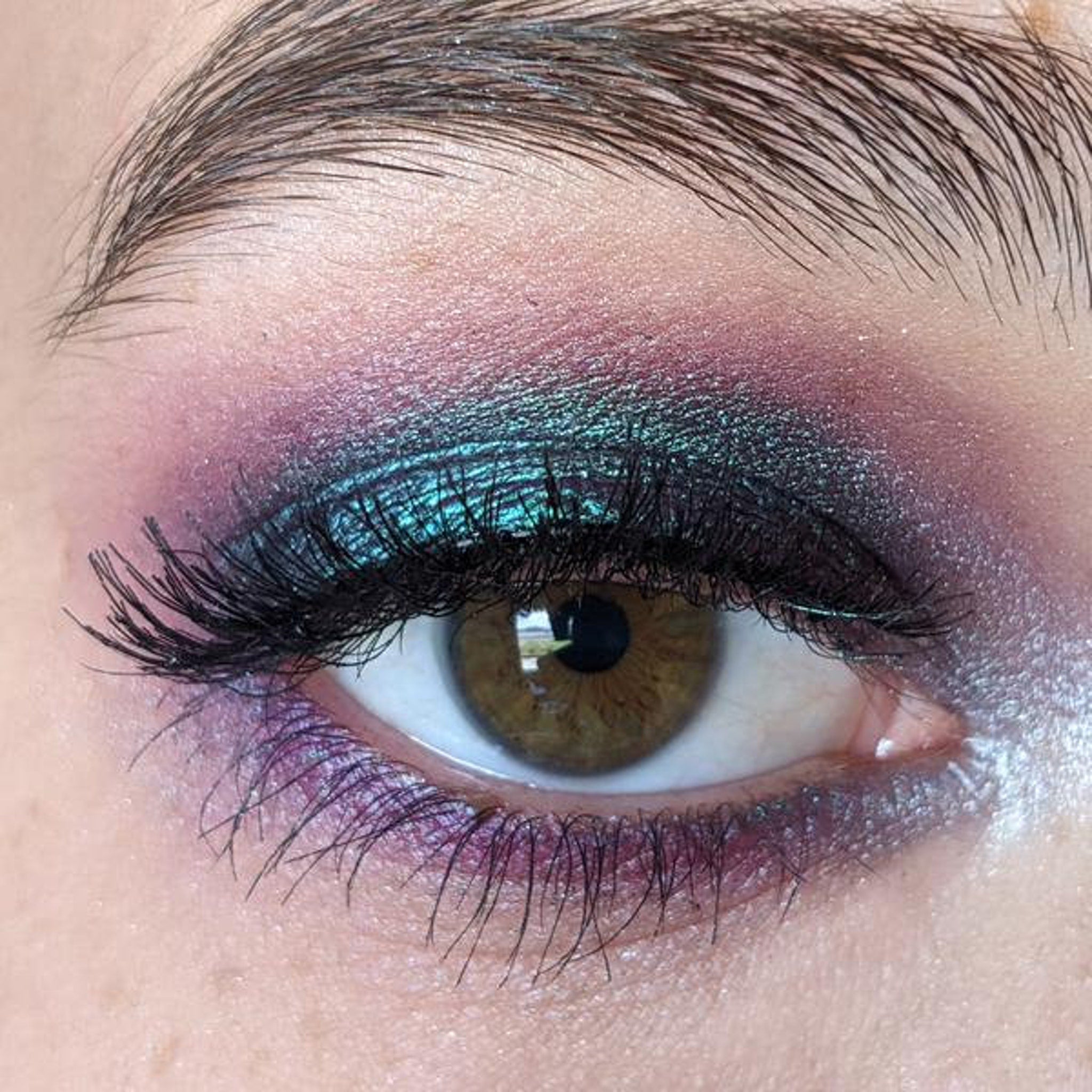 Close-up of shimmering masquerade eye shadow palette with vibrant jewel tones and smooth satin finish