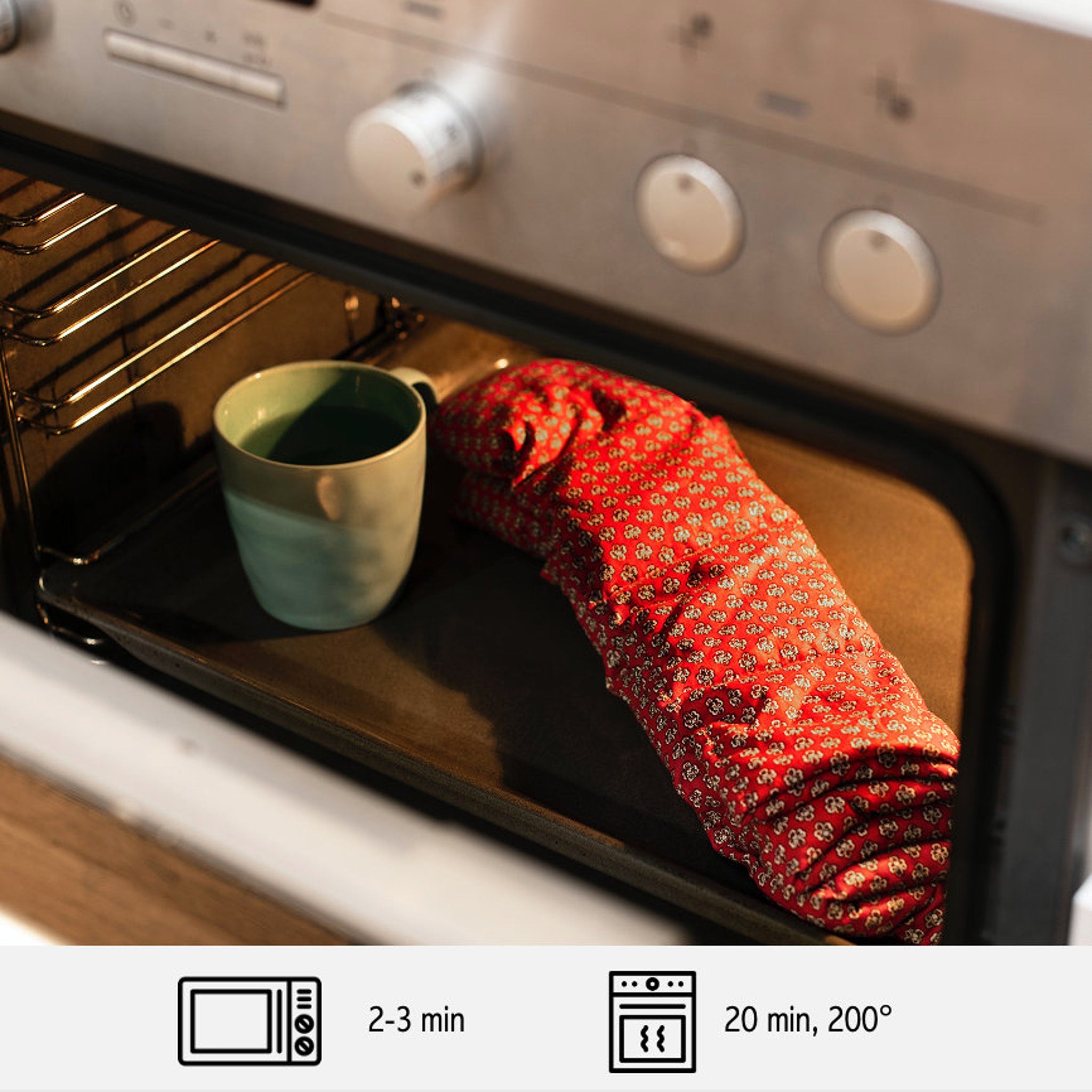 Oven mitt with red floral pattern, used with a mug and baking sheet inside oven