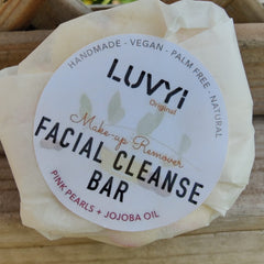 Facial cleanse bar wrapped in white paper with LUVVI label, pink accents, natural ingredients