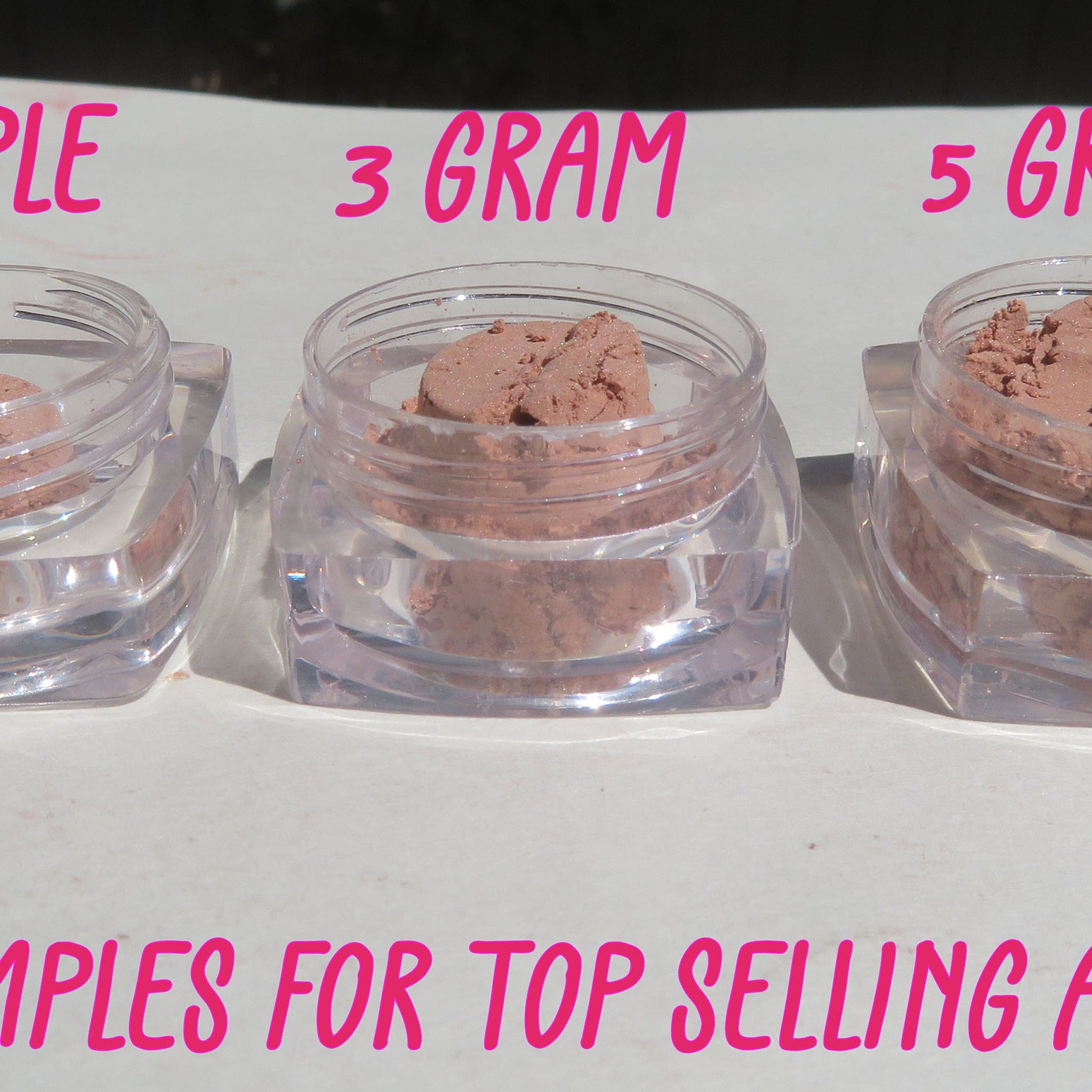 Powder samples in clear plastic jars, pink powder, 3 gram label visible