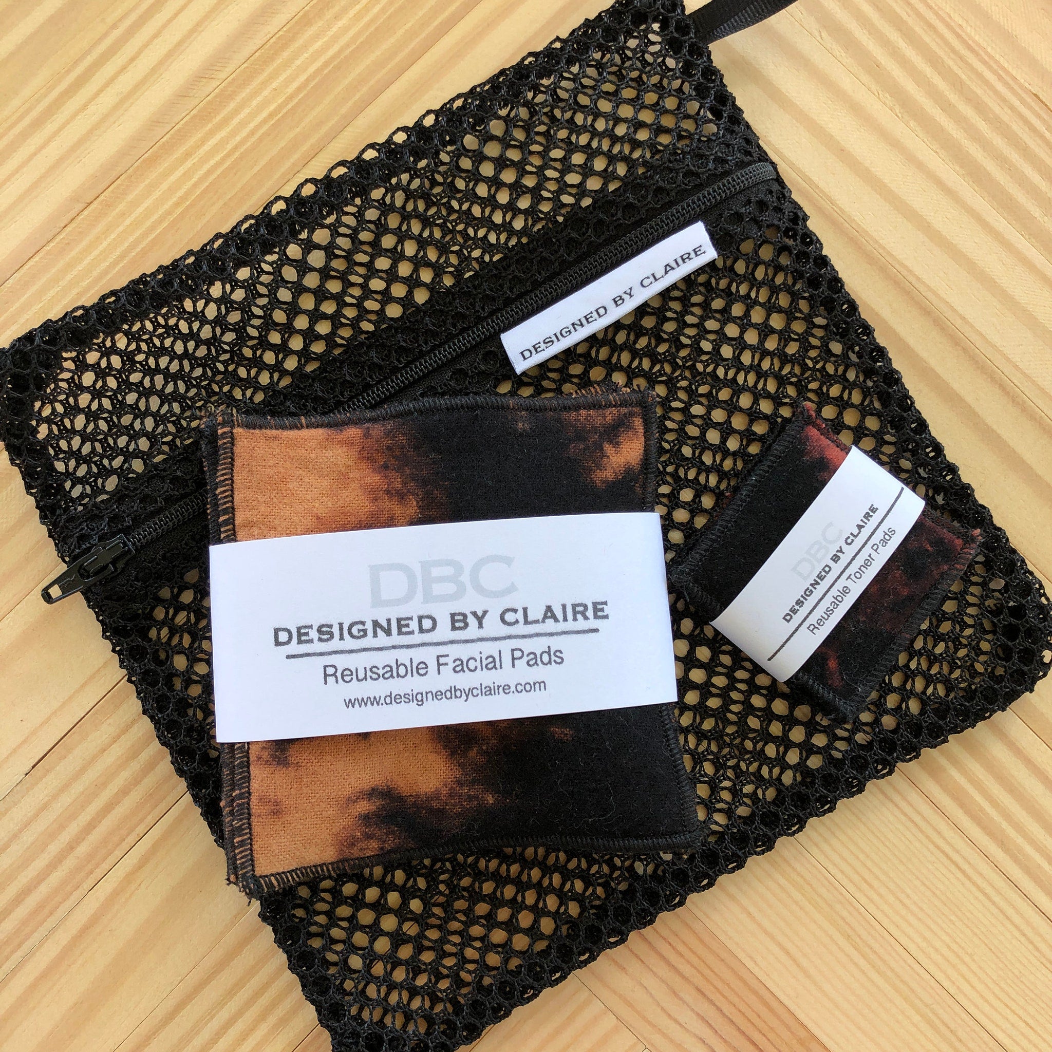 Reusable facial pads with tie-dye pattern, black mesh bag, and "Designed by Claire" label