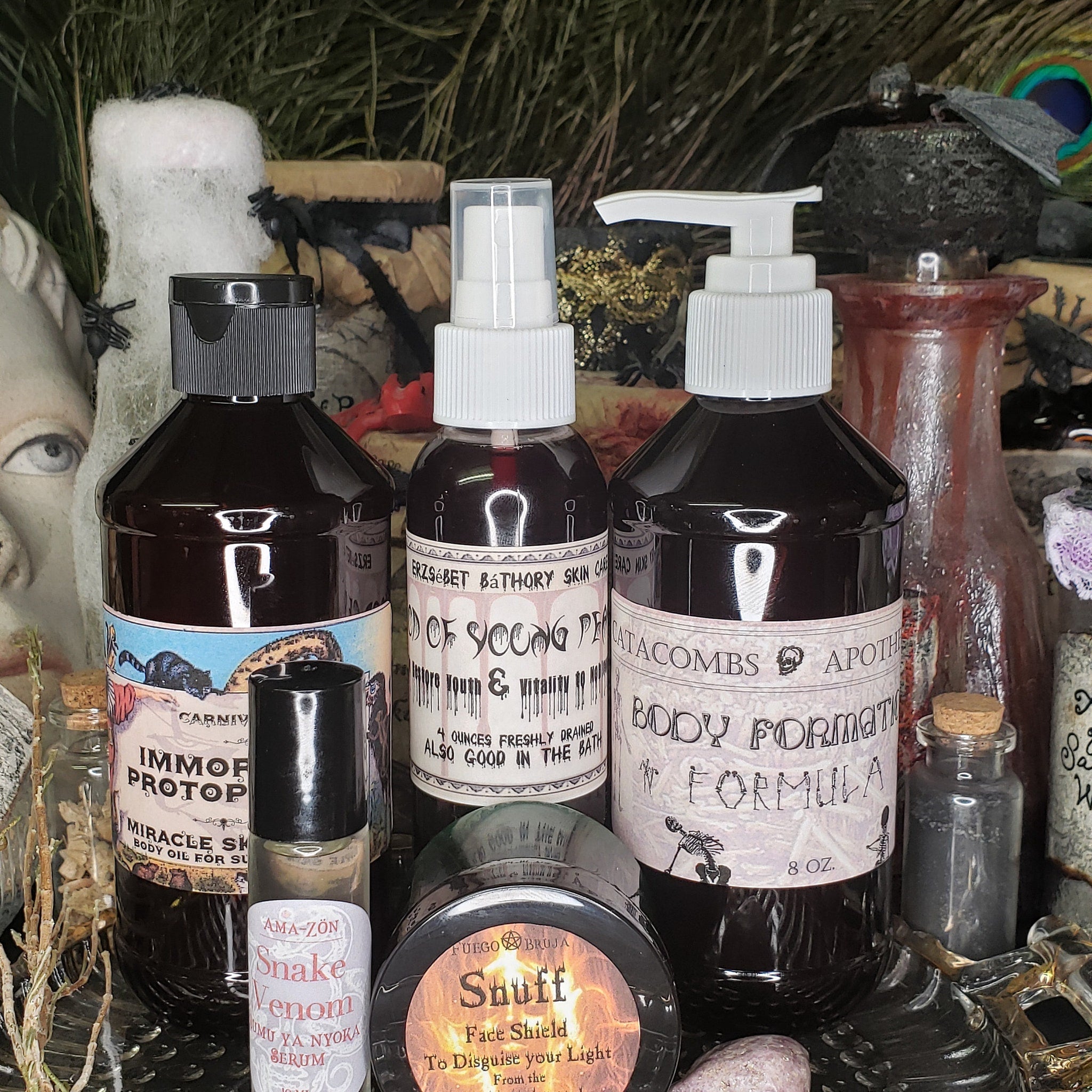 Body oil bottles with black and white labels, dark liquid, and white spray tops, various sizes