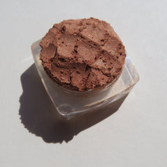Side view of loose mineral eyeshadow in bronze copper brown shimmer, showcasing fine powder texture and reflective particles