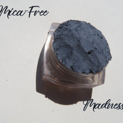 Hand applying matte taupe loose mineral eyeshadow with a fluffy brush for a soft blended look