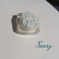 Pale green matte loose mineral eyeshadow in a clear jar with black screw-top lid, vegan and cruelty-free.