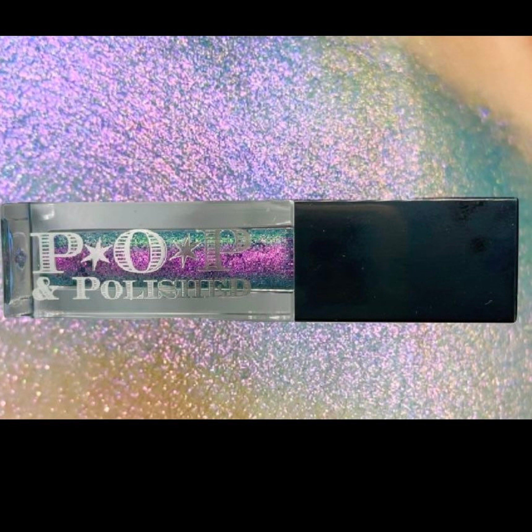 Vibrant purple multichrome liquid eyeshadow shifting to blue, green, and pink in sleek tube with doe-foot applicator