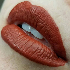 Side view of rusty red and orange vegan eyeshadow palette showing textured powder surface and heart-shaped pan design