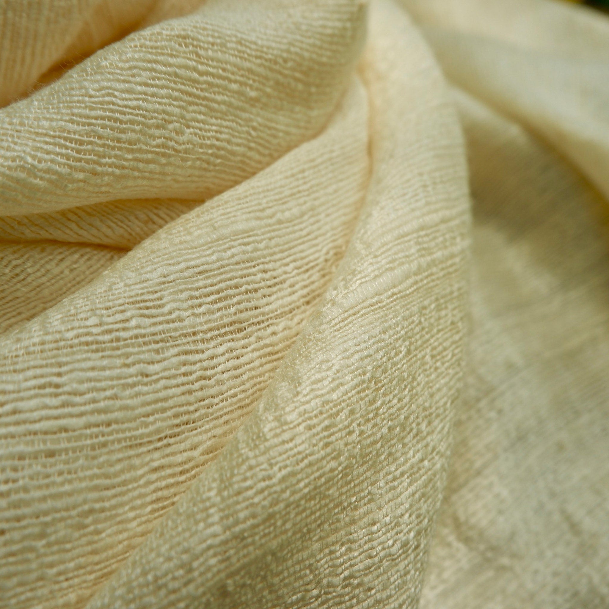Cream-colored fabric with textured weave and draped style.