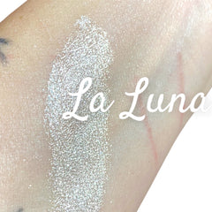 Side view of LA LUNA iridescent white eyeshadow pot showing silvery glitter texture and reflective finish