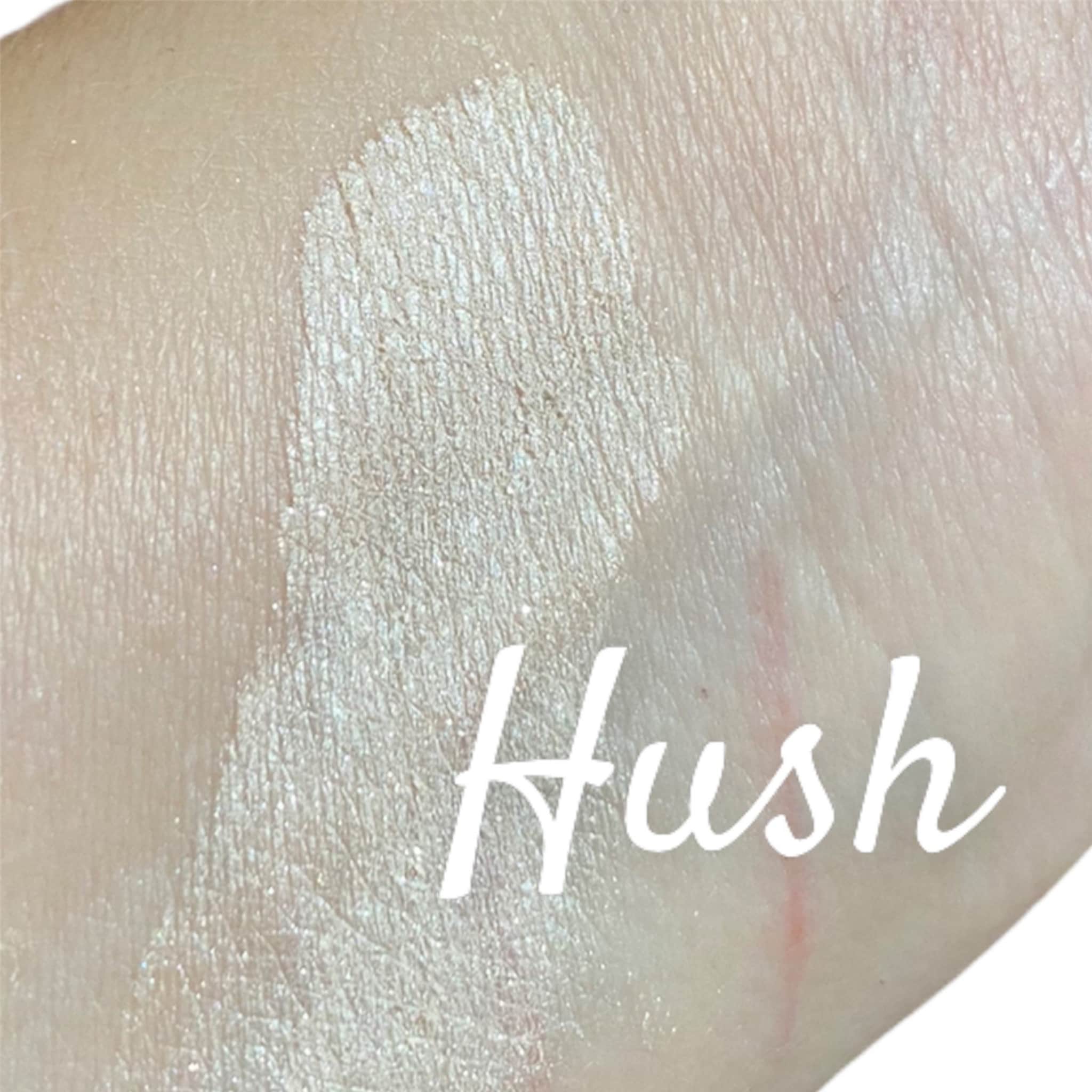 Swatch of Hush with light shimmer and white text on skin, showing texture